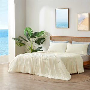 Cream-colored cooling comforter on bed with cozy bedding, creating a relaxing bedroom atmosphere. #Color_Snow Ivory