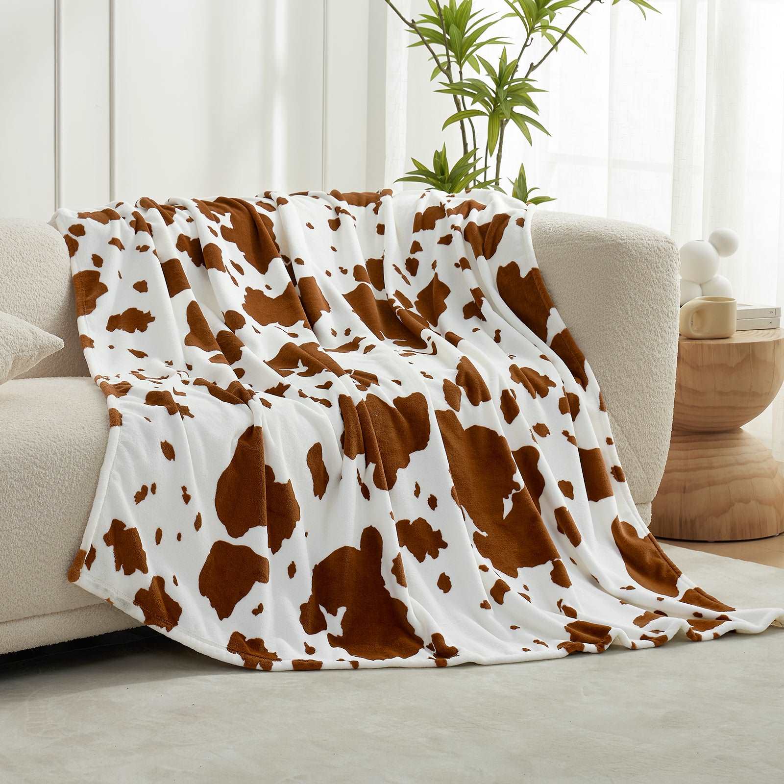 Cozy Bliss cow print throw blanket on a white couch #color_Brown