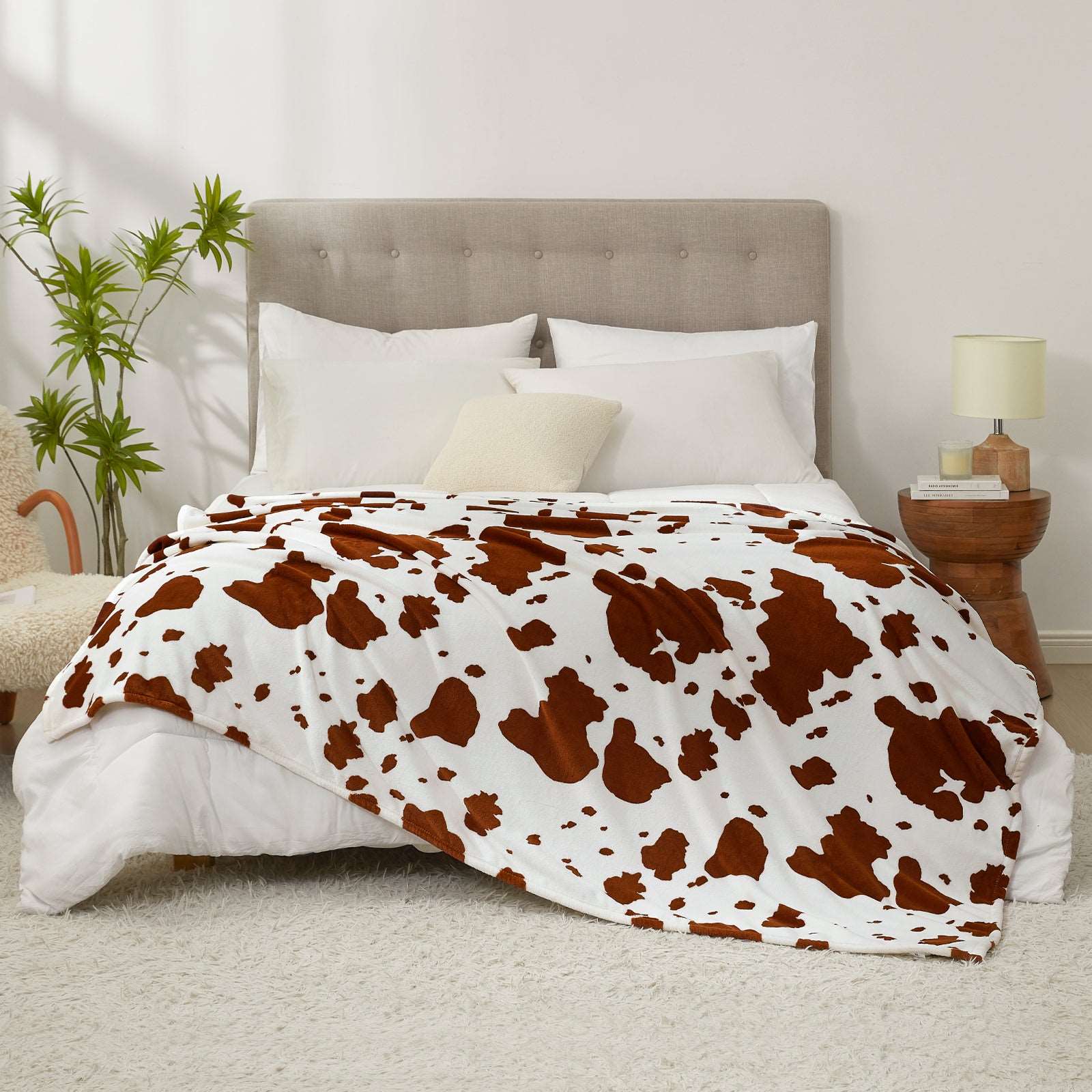 Cozy Bliss cow print blanket on a bed #color_Brown