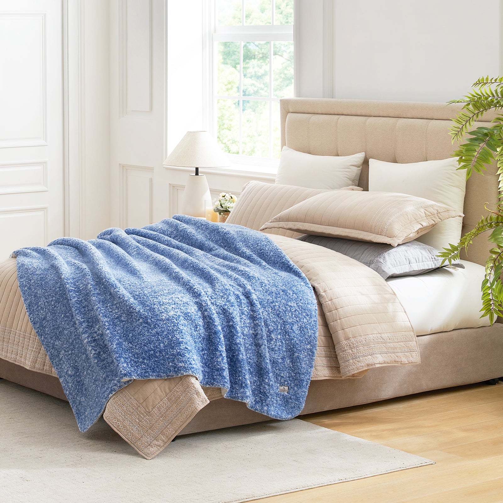 Cozy Bliss blue sherpa throw blanket on a bed. Soft and breathable cozy bedding for comfort. #color_ Mottled Navy Blue