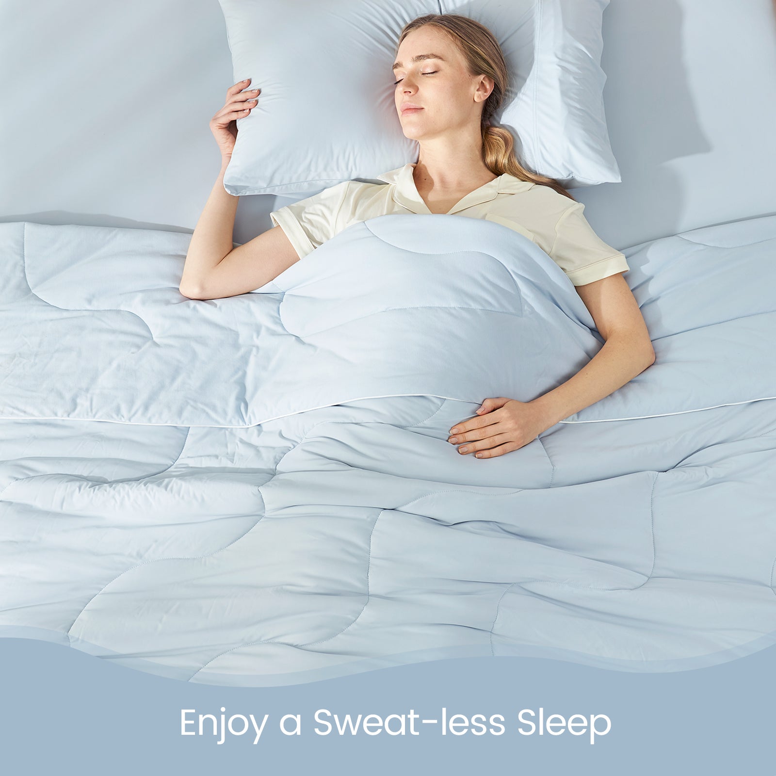 Woman sleeping comfortably under Cozy Bliss cooling comforter #color_Cool Blue