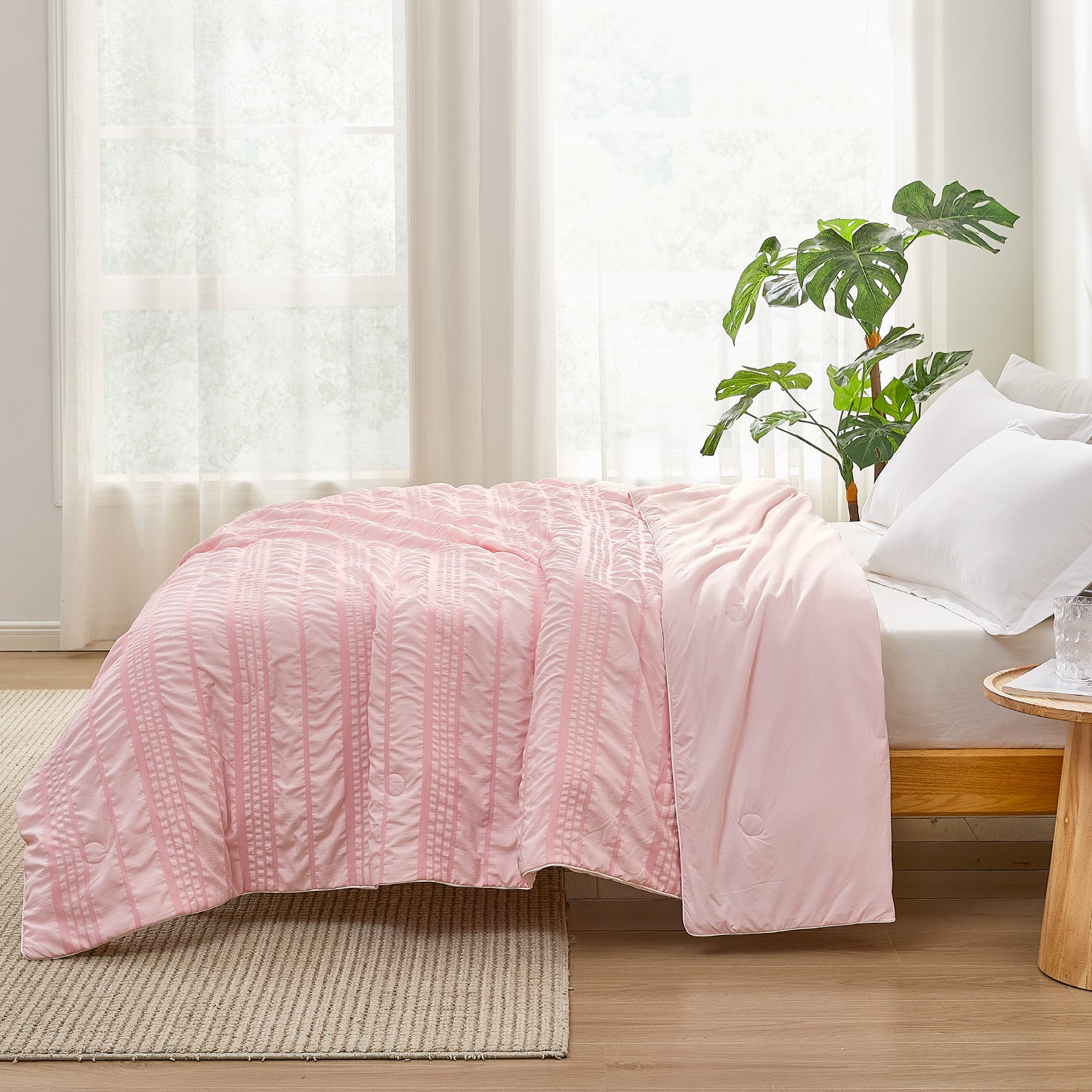 Cozy Bliss pink Seersucker Cooling Comforter on a bed, promoting cool and breathable sleep with a soft blanket #color_Pink