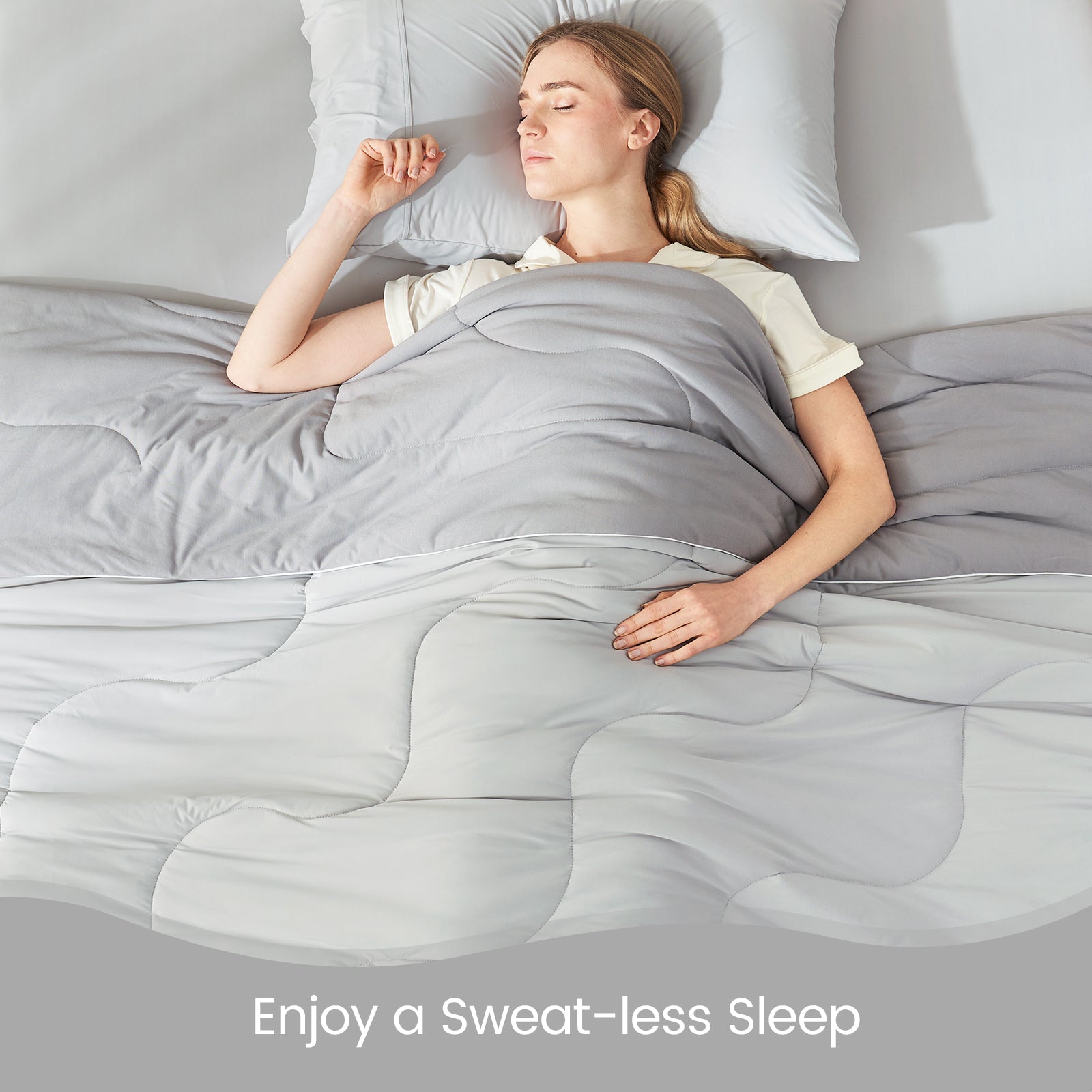 Woman sleeping under Cozy Bliss cooling comforter, promoting sweat-free sleep, featuring breathable design. #color_Cool Grey