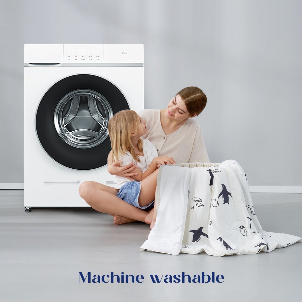 Woman and child with a machine washable comforter in front of a washing machine.#color_Antarctic Penguin