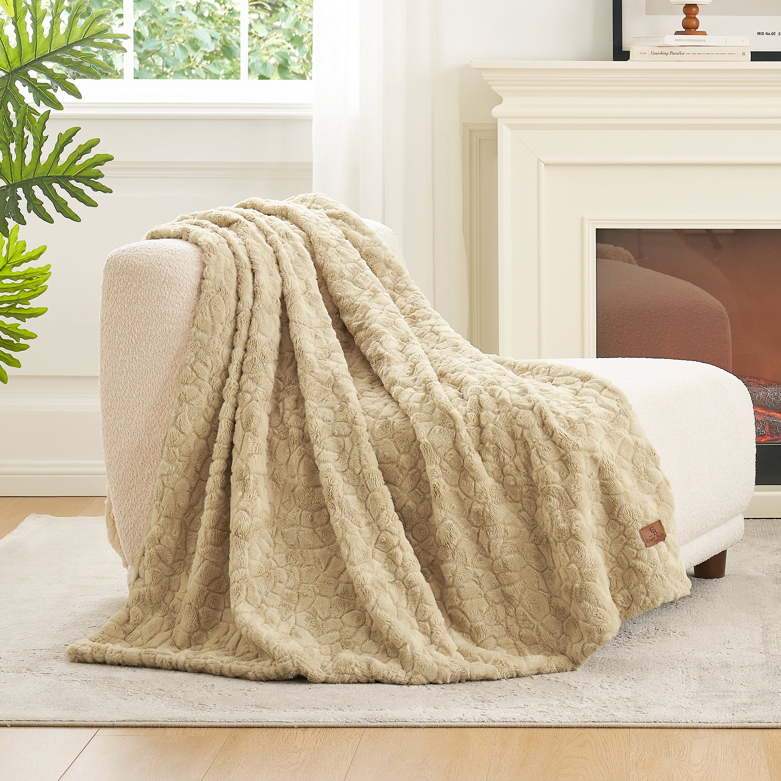 Beige textured blanket draped over a white armchair in a cozy living room. #color_Khaki