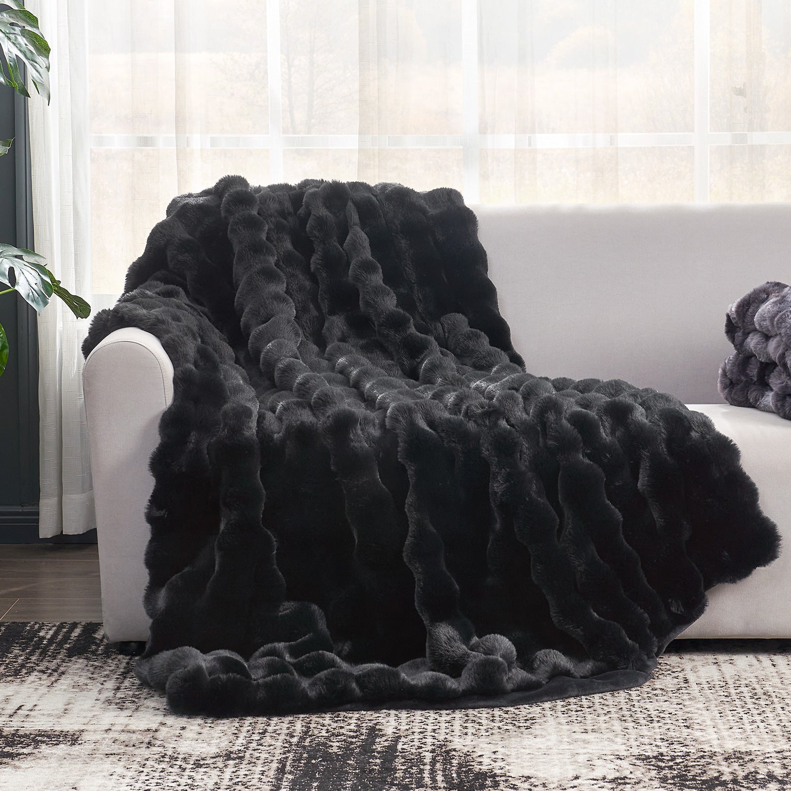 Black Cozy Bliss Bubble Faux Fur Throw Blanket on white sofa. Soft, cozy, luxurious blanket. #color_Black