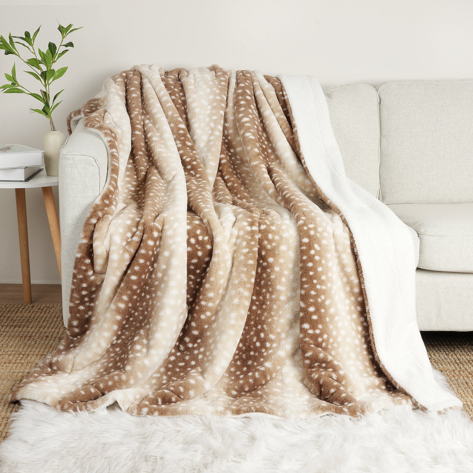 Deer print faux fur throw blanket draped over a sofa. Cozy and stylish for a warm living space. #color_Brown