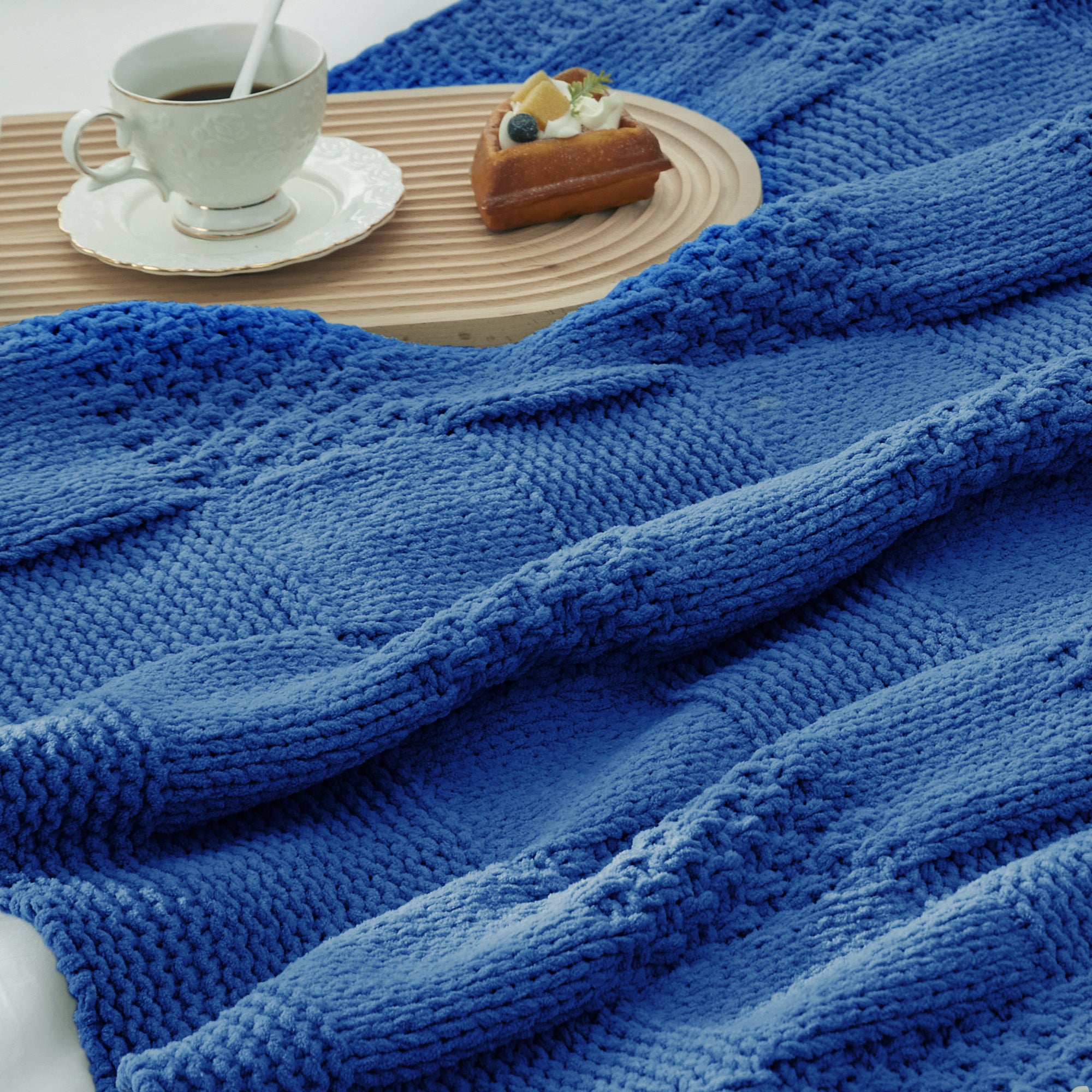 Close-up of Checkered Chenille Knit Throw Blanket in Blue showcasing textured chenille knit pattern with a cozy tea and dessert setting. #color_Dark Blue