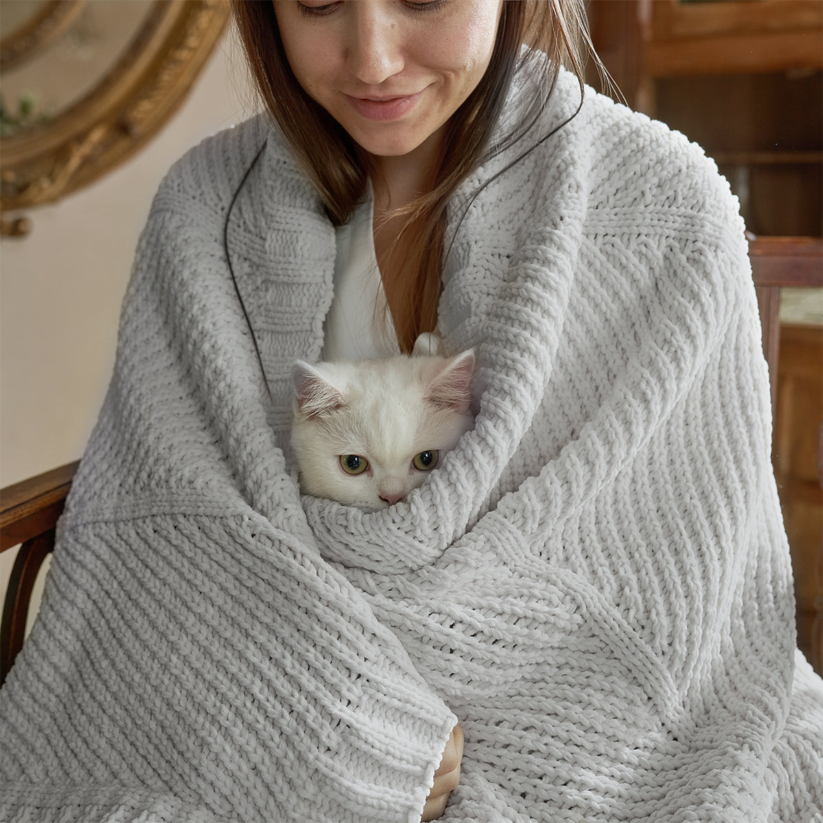 Person wrapped in a cozy light grey blanket with a white cat peeking out. #color_Light Grey