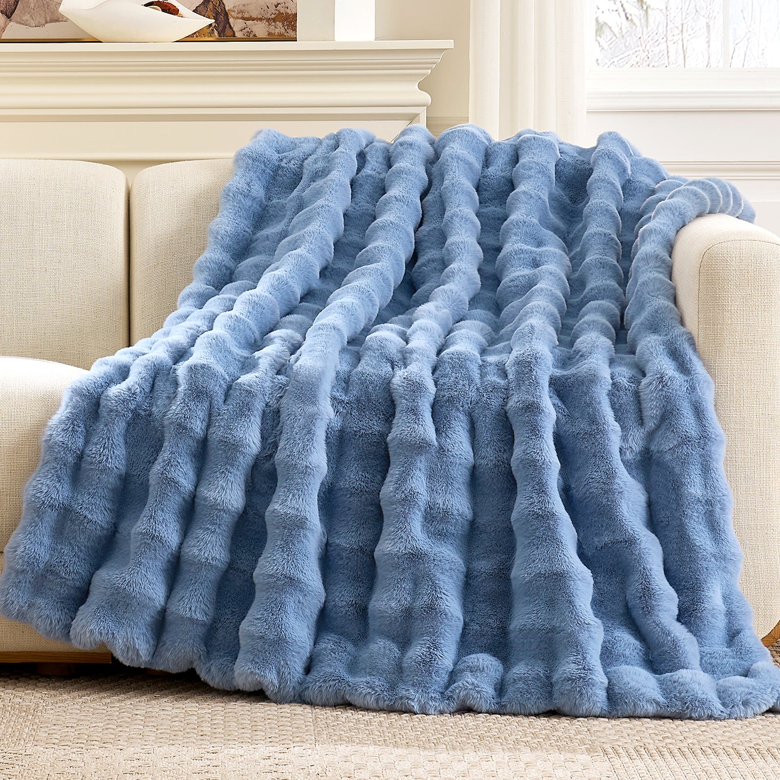 Cozy Bliss Bubble Faux Fur Throw Blanket draped over a couch #color_Misty Blue