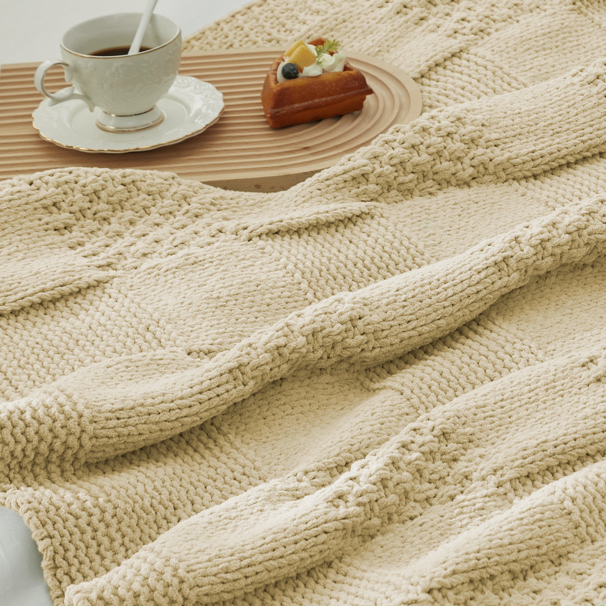 Close-up of Checkered Chenille Knit Throw Blanket in Beige showcasing textured chenille knit pattern with a cozy tea and dessert setting. #color_Beige