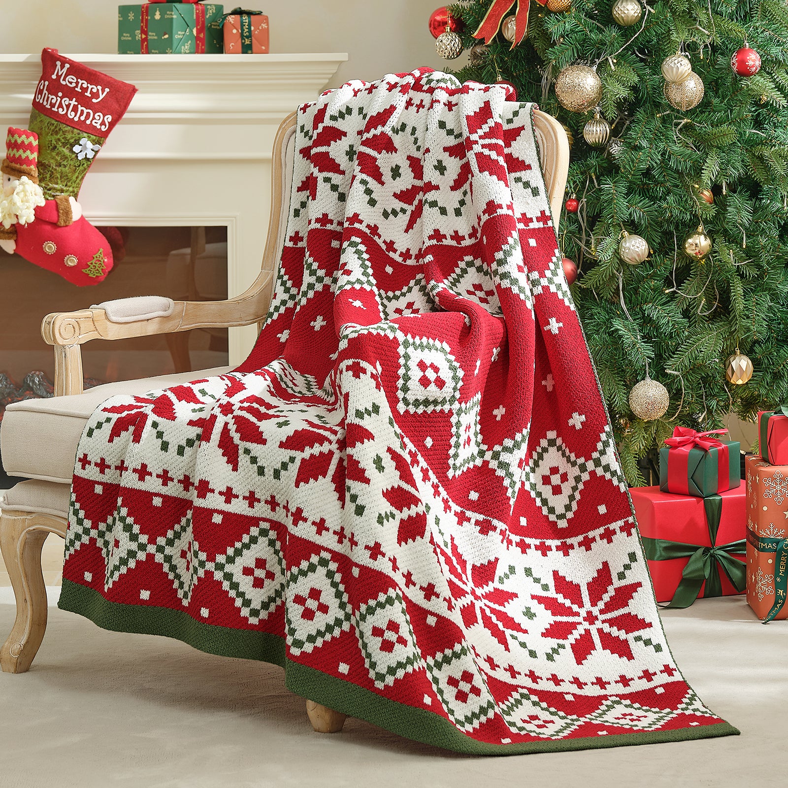Red and white patterned blanket draped over a chair in a festive room with Christmas tree and presents. #color_Fair Isle