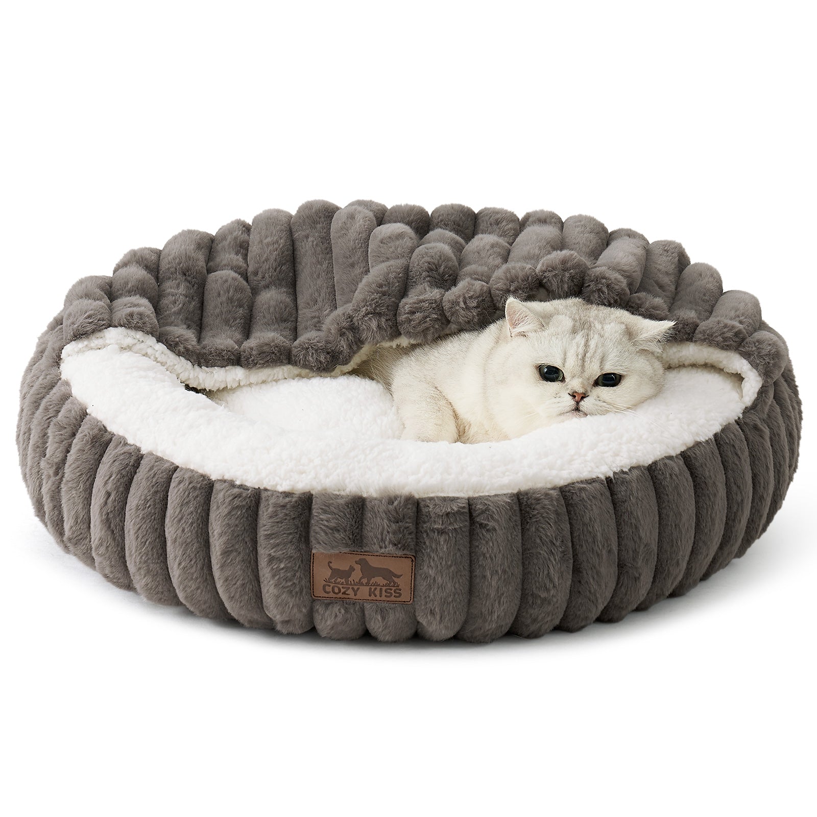 Cat lying on a fluffy grey faux fur pet bed with hooded blanket in a cozy room with wooden furniture and a rug.#color_Grey
