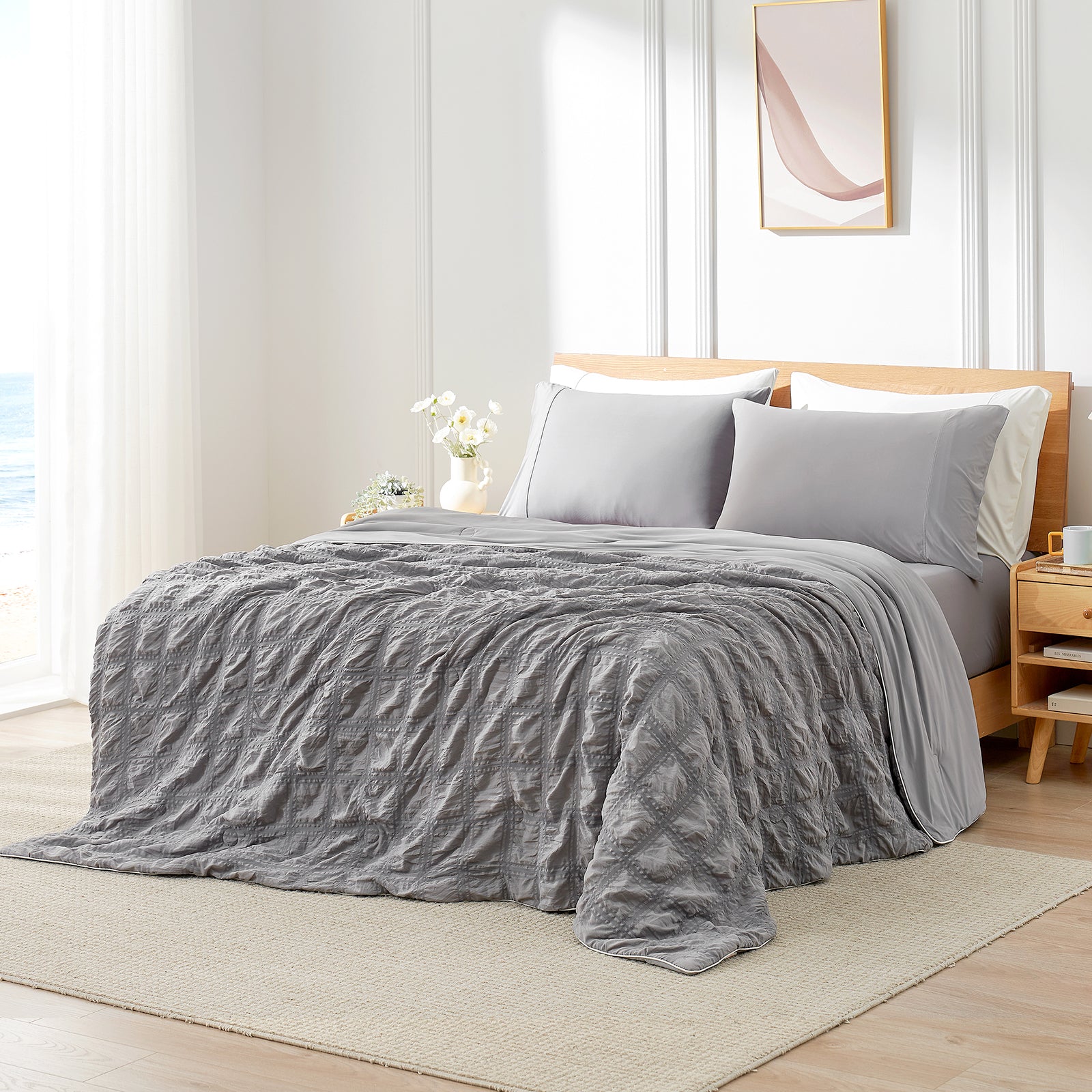 Gray textured blanket on a bed in a bedroom setting with a wooden headboard and side table. #color_Dark Gray