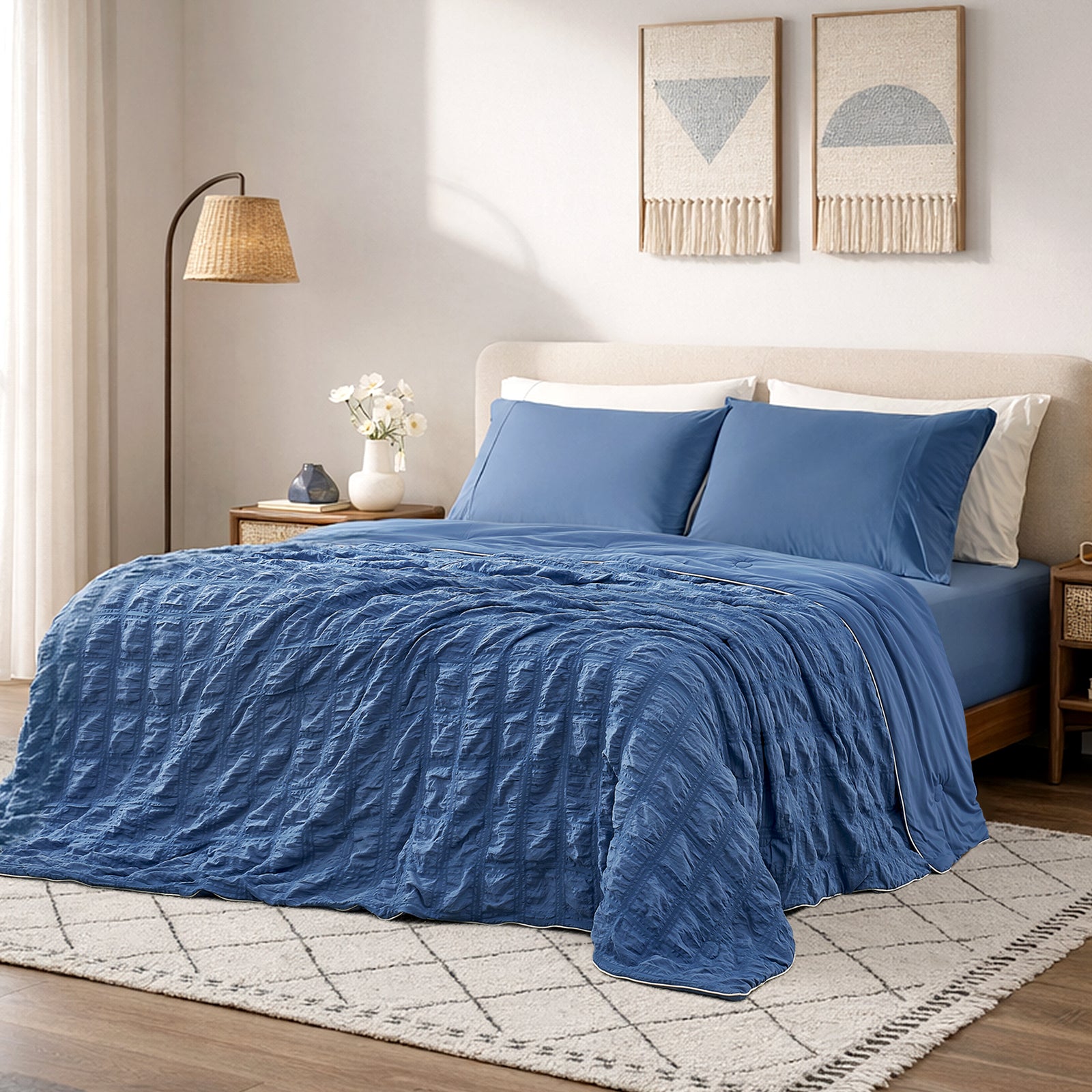 Cozy Bliss denim blue seersucker cooling comforter in bright cozy bedroom, breathable lightweight bedding with textured fabric.#color_Denim Blue
