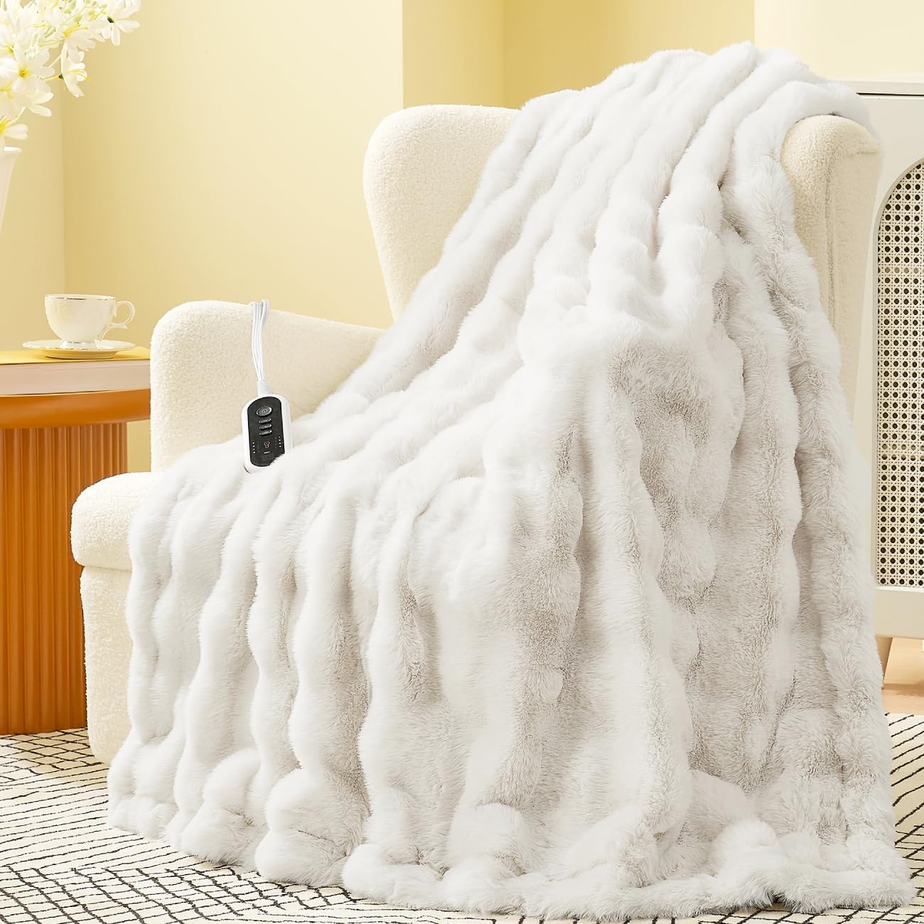 White electric blanket draped over a chair with a remote control in a cozy room. #color_Cream White