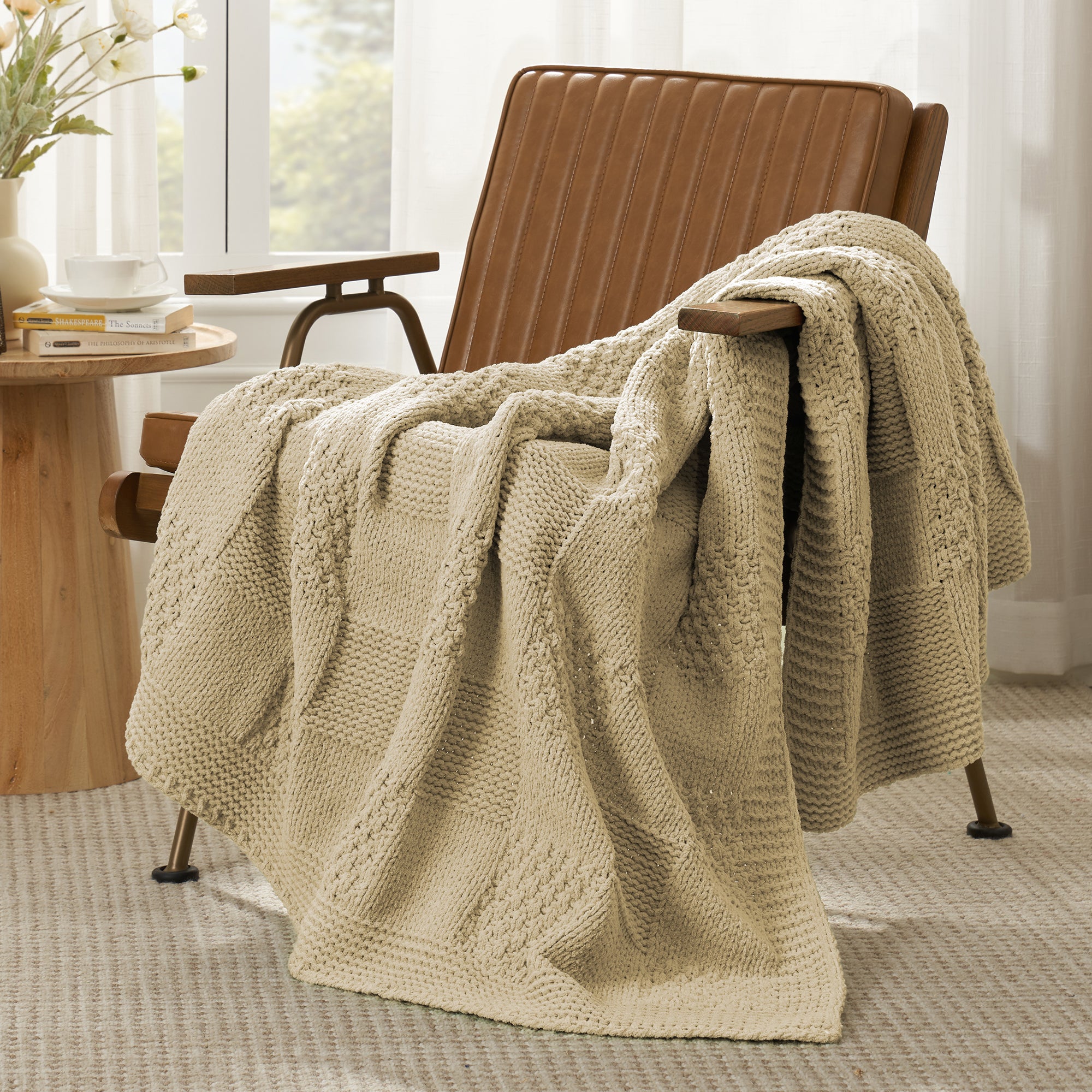 Checkered Chenille Knit Throw Blanket in Beige draped over a lounge chair, showcasing soft chenille knit texture and cozy checkered design. #color_Beige