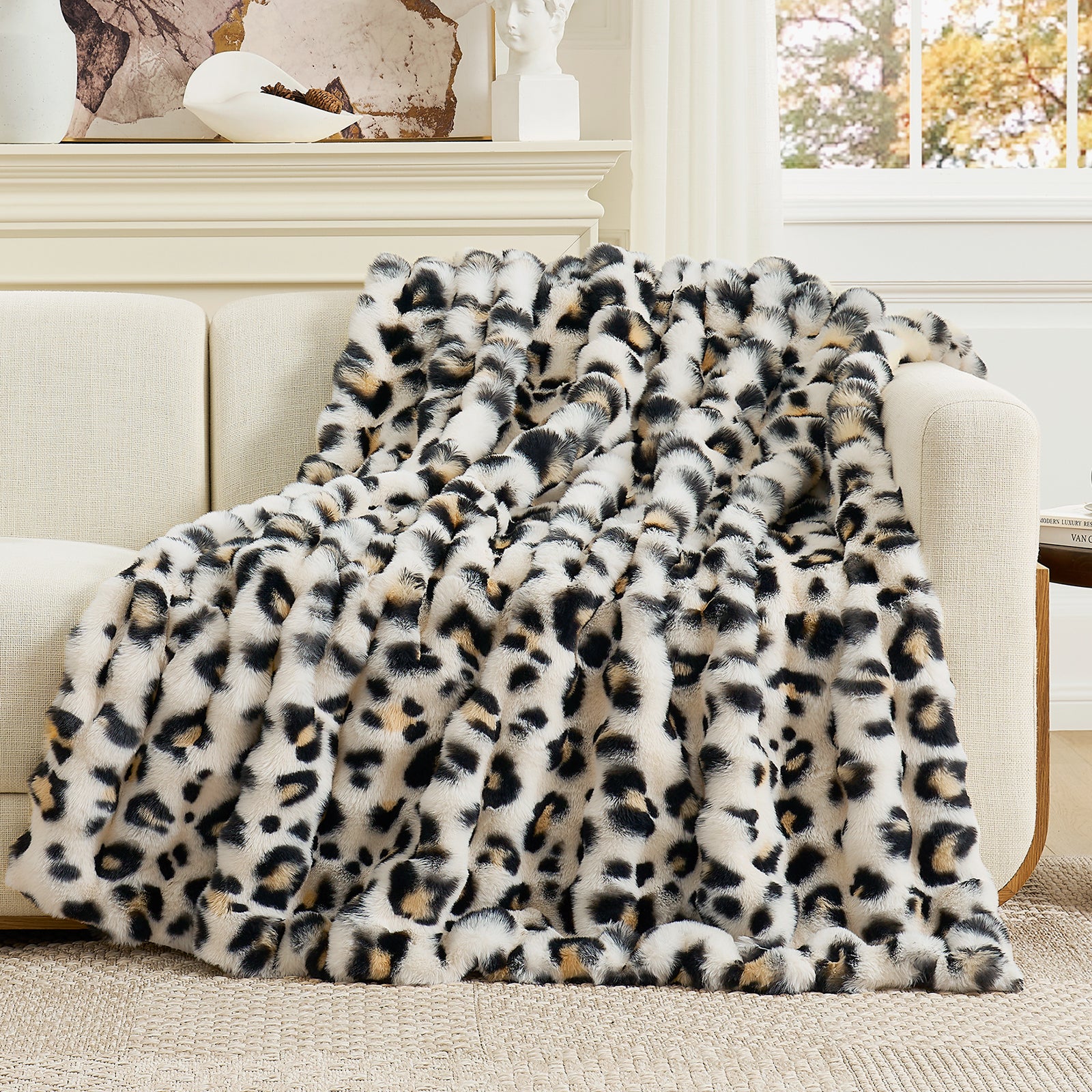Leopard print blanket draped over a white sofa in a living room setting. #Color_Leopard
