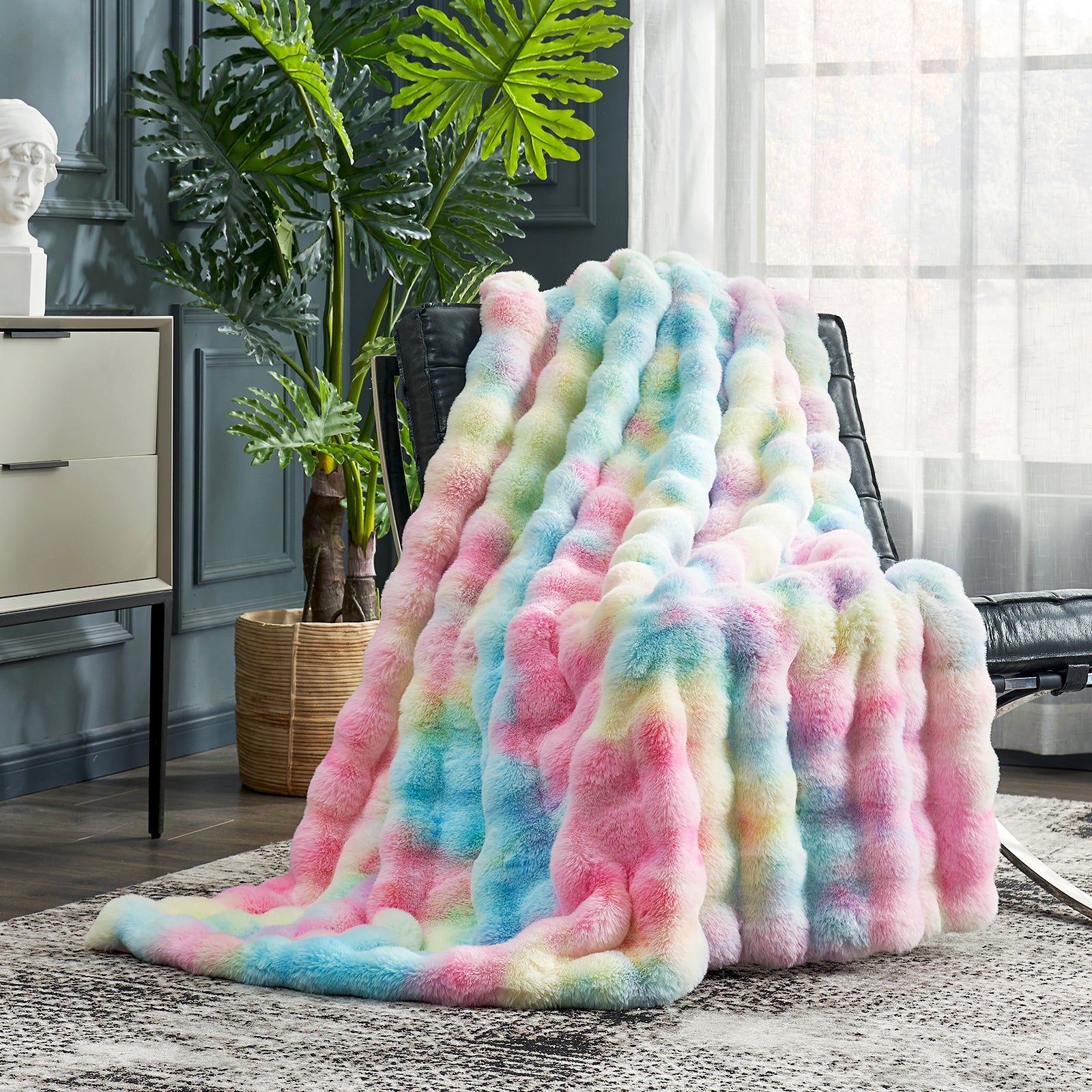 Multicolored fuzzy blanket draped over a chair in a room with plants and furniture. #color_Tie-dye Rainbow