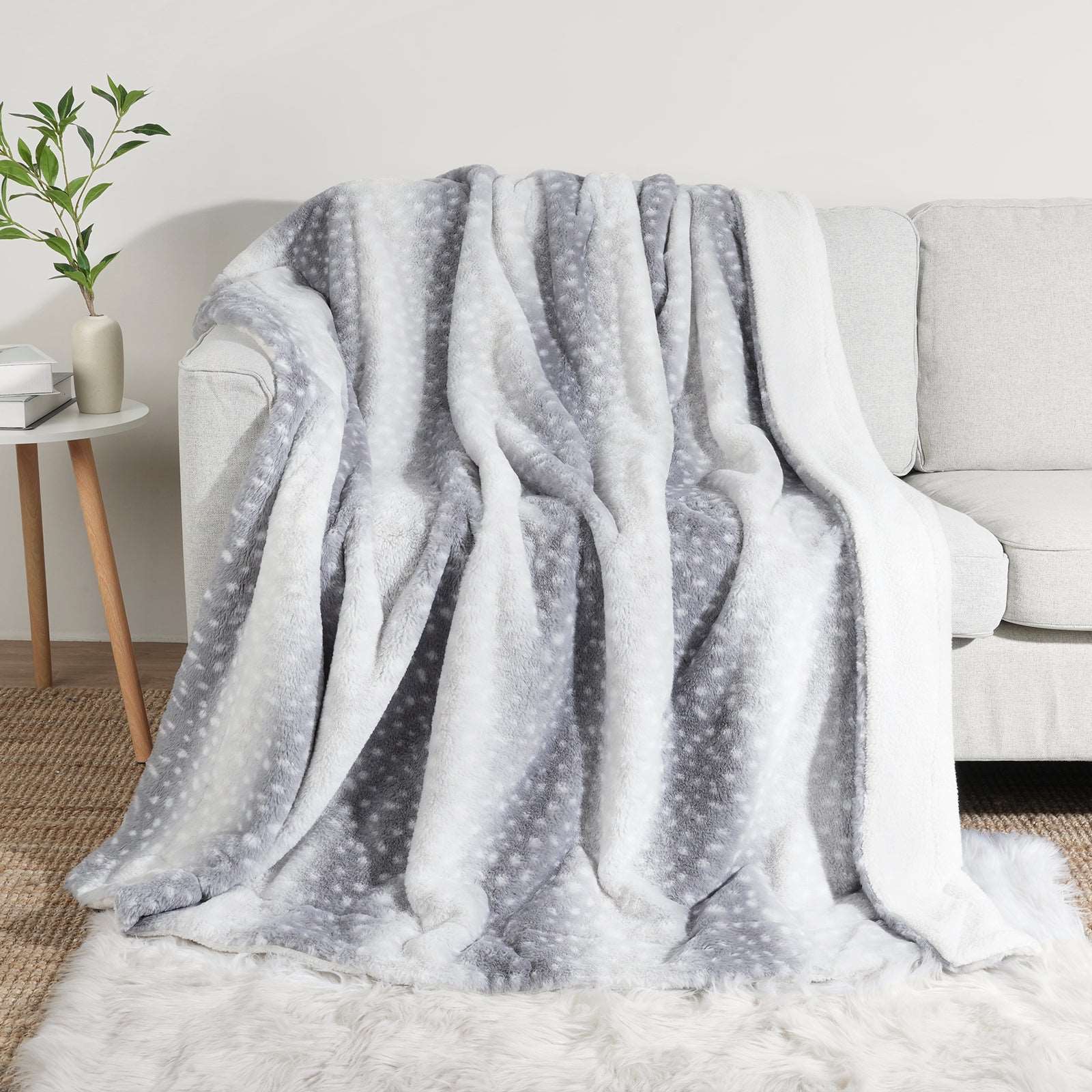 Gray deer print faux fur blanket on sofa. Cozy, soft, breathable bedding for living room or bedroom. #color_Silver Sherpa