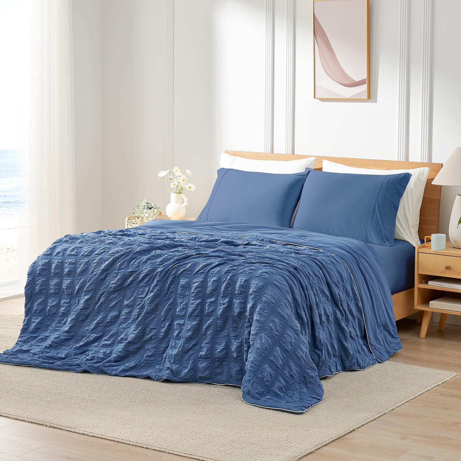 Blue textured bedspread on a bed in a bedroom setting with light decor. #color_Denim Blue