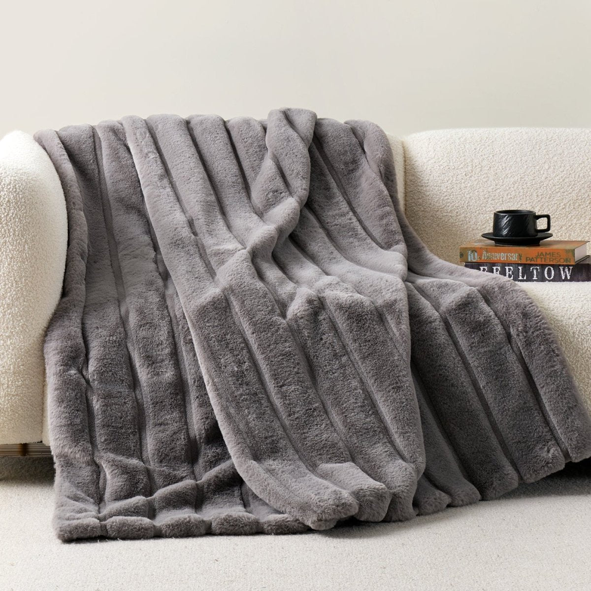 Cozy Bliss sheared faux fur throw blanket draped over a sofa, showcasing elegant ribbed texture #color_Grey