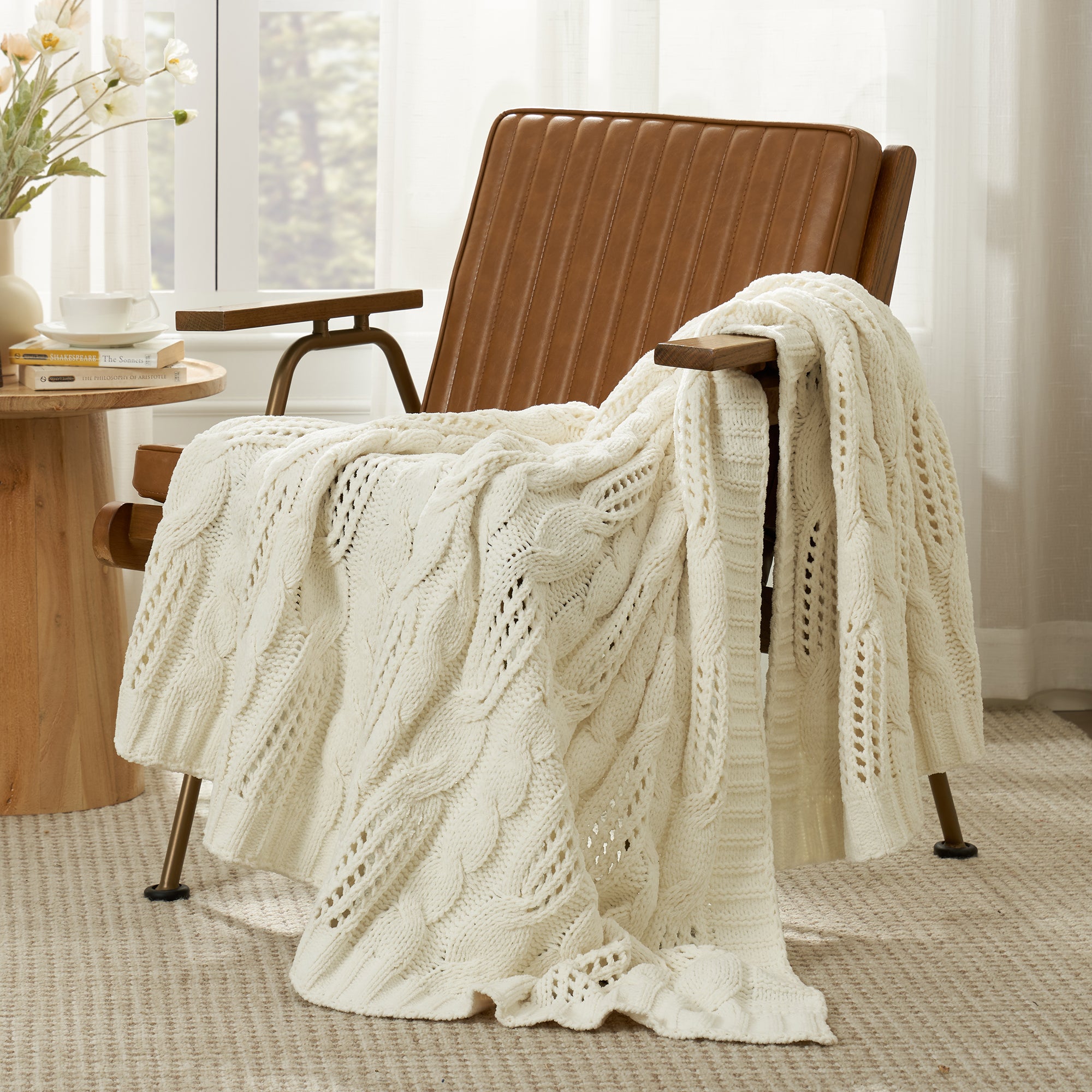 Chenille Cable Knit Throw Blanket in Ivory front view draped over an armchair, showcasing soft chenille texture and elegant knit design. #color_Ivory