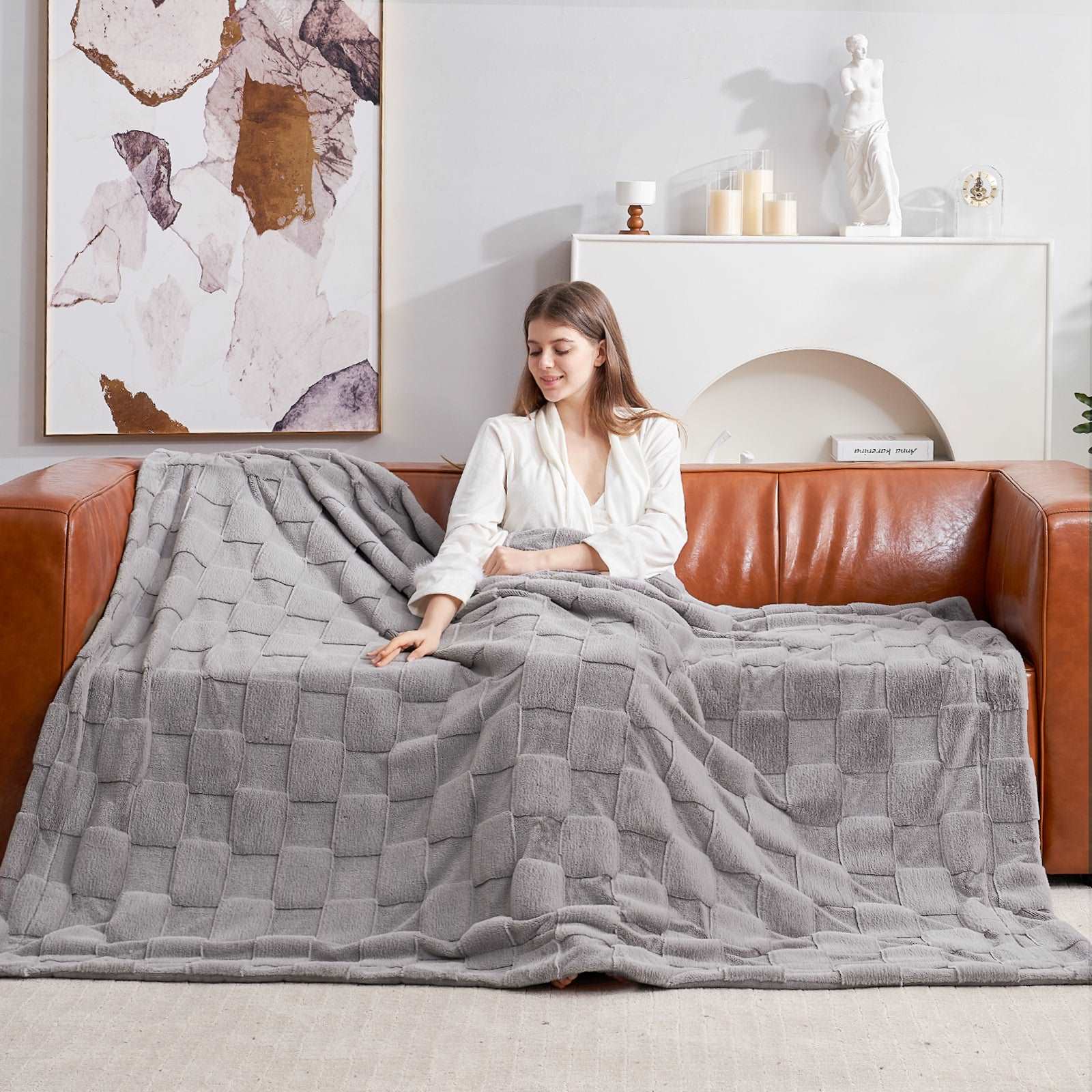 Woman relaxing with Cozy Bliss grey checkboard faux fur blanket #color_Grey