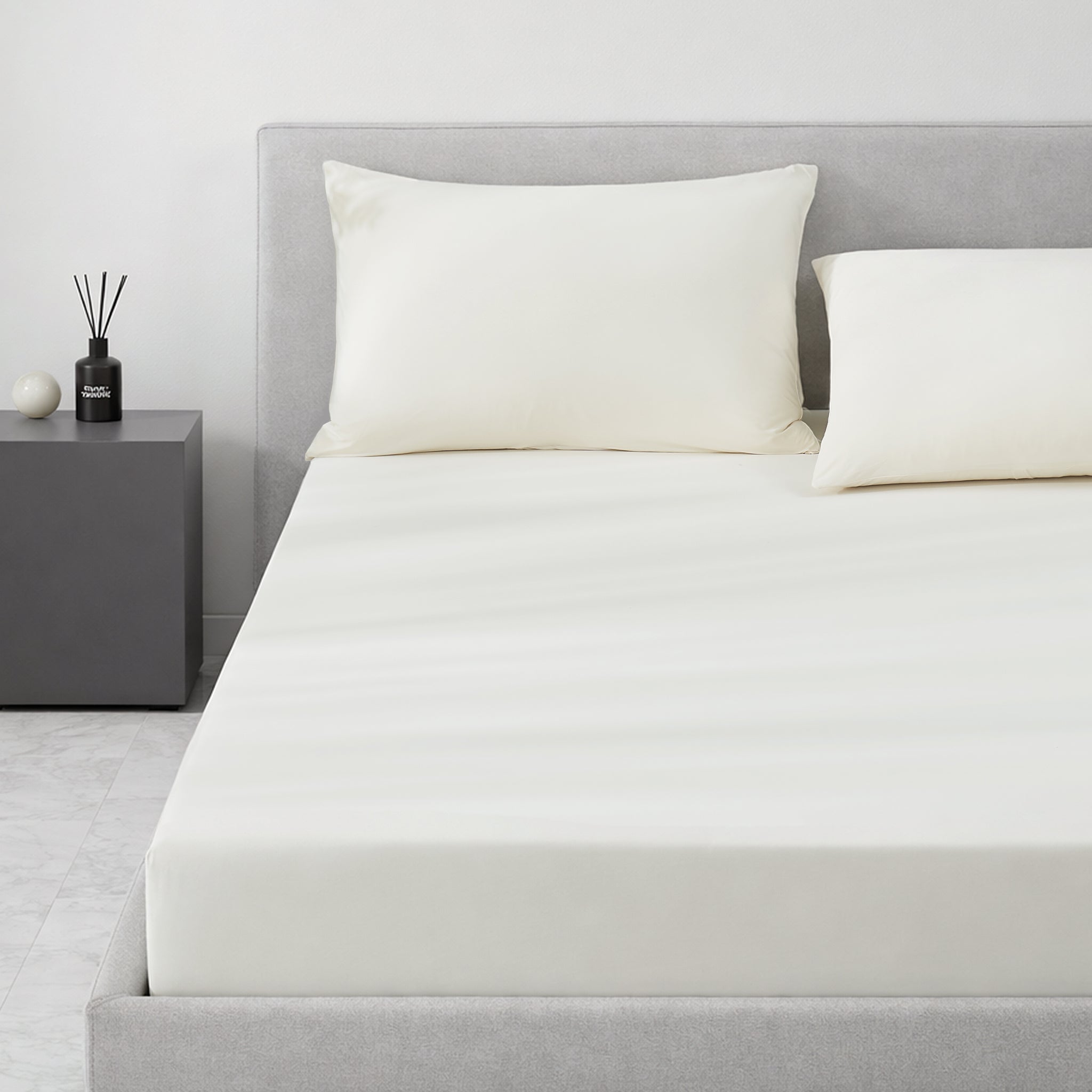 Gray cooling bedding set on a bed in a minimalistic bedroom setting.#color_Ivory