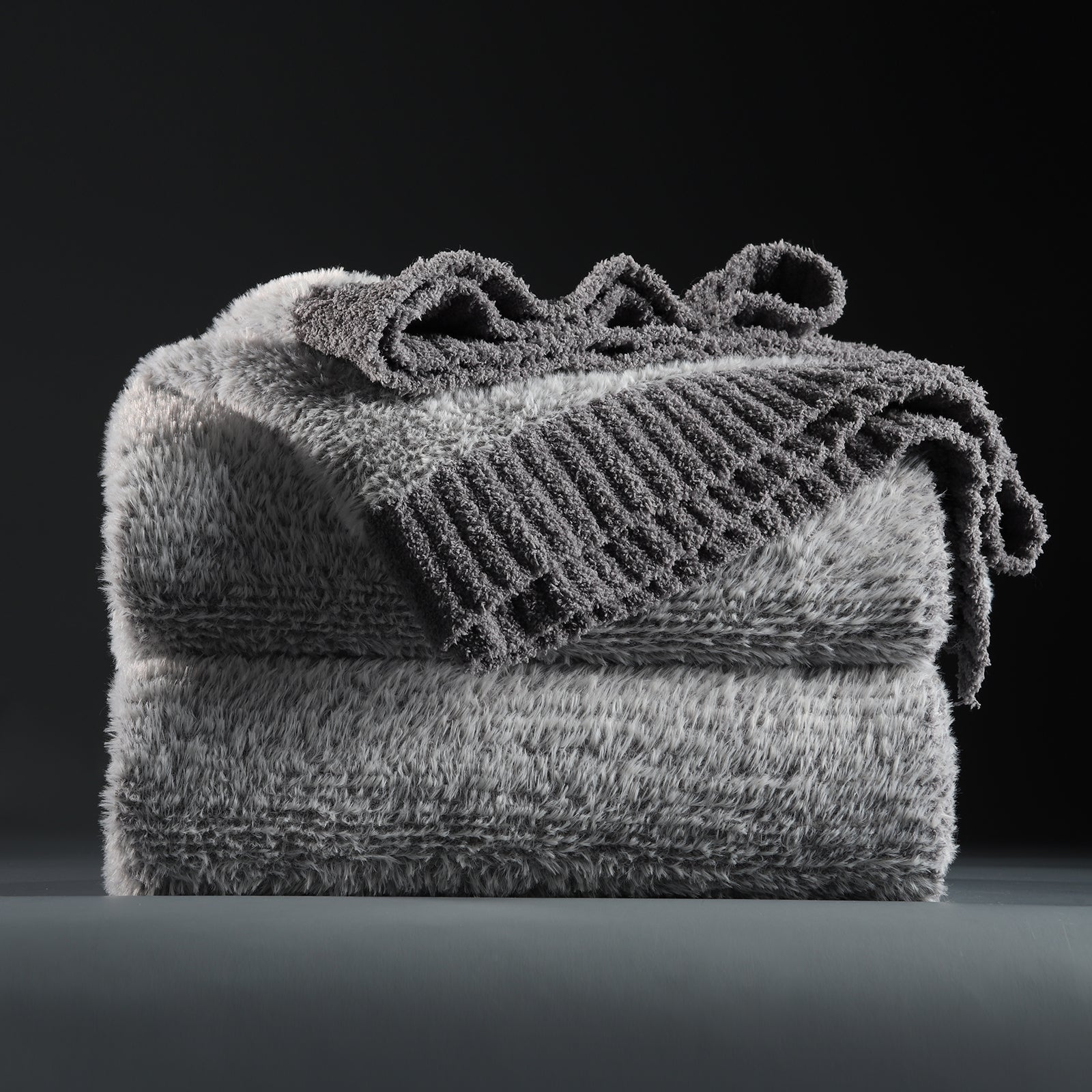 Faux Mink Feather Knit Throw Blanket in Grey neatly folded stack, showcasing soft feather yarn and premium texture. #color_Grey