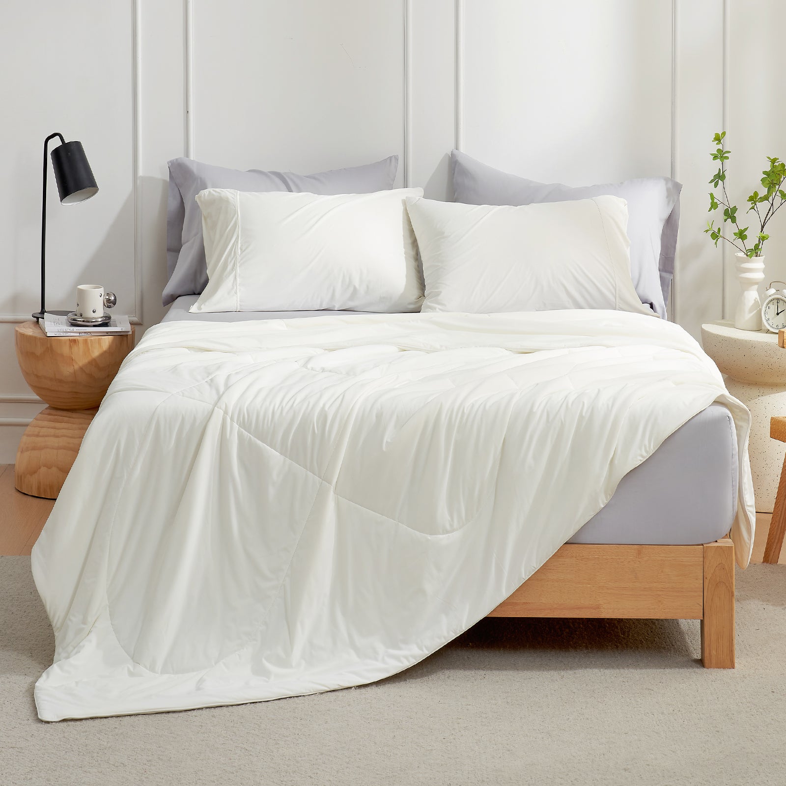White cooling comforter and pillows on a bed, offering soft, breathable comfort for a cozy sleep experience. #Color_Off White