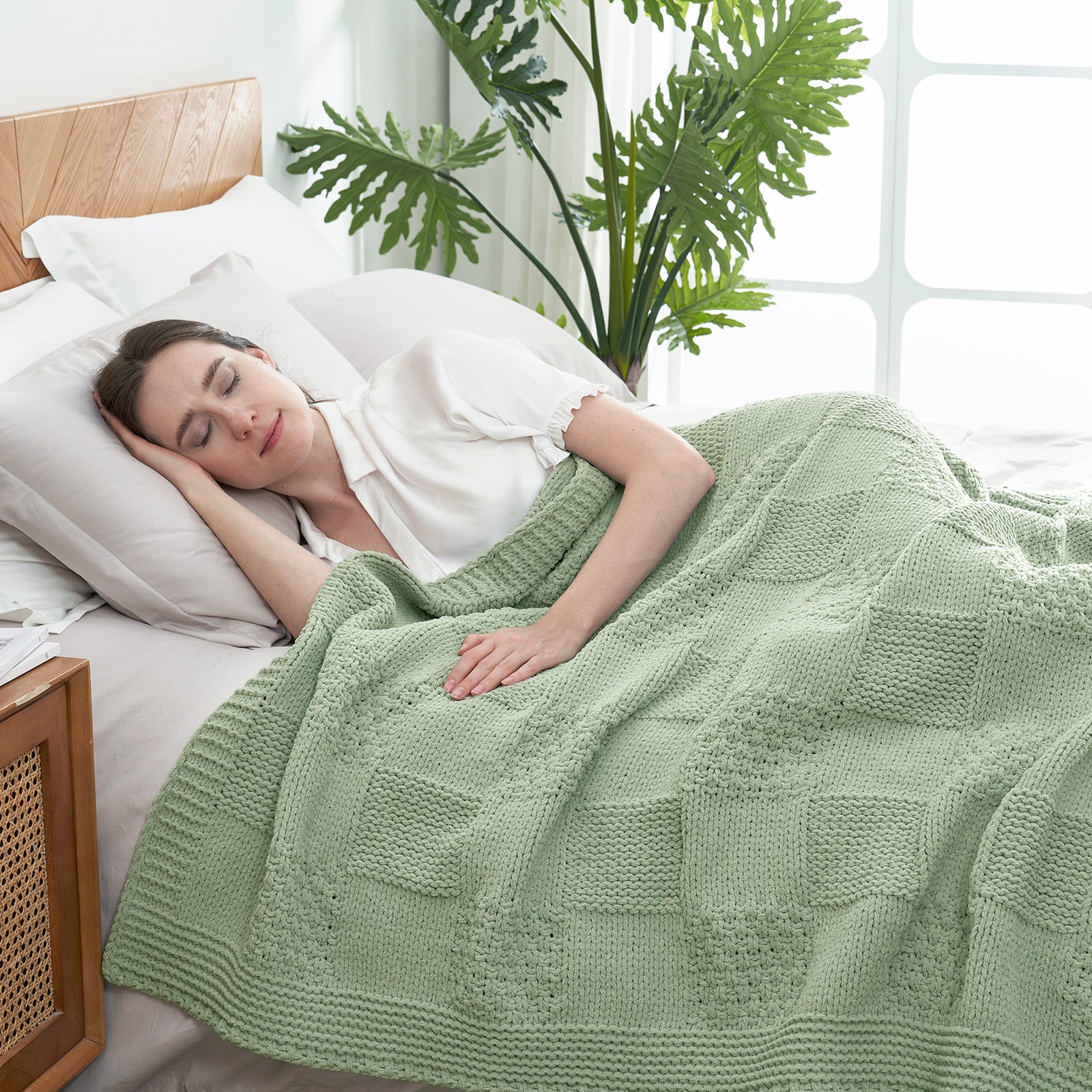 Woman sleeping under Checkered Chenille Knit Throw Blanket in Sage Green in a bright bedroom setting, enjoying warmth and breathable comfort. #color_Sage Green
