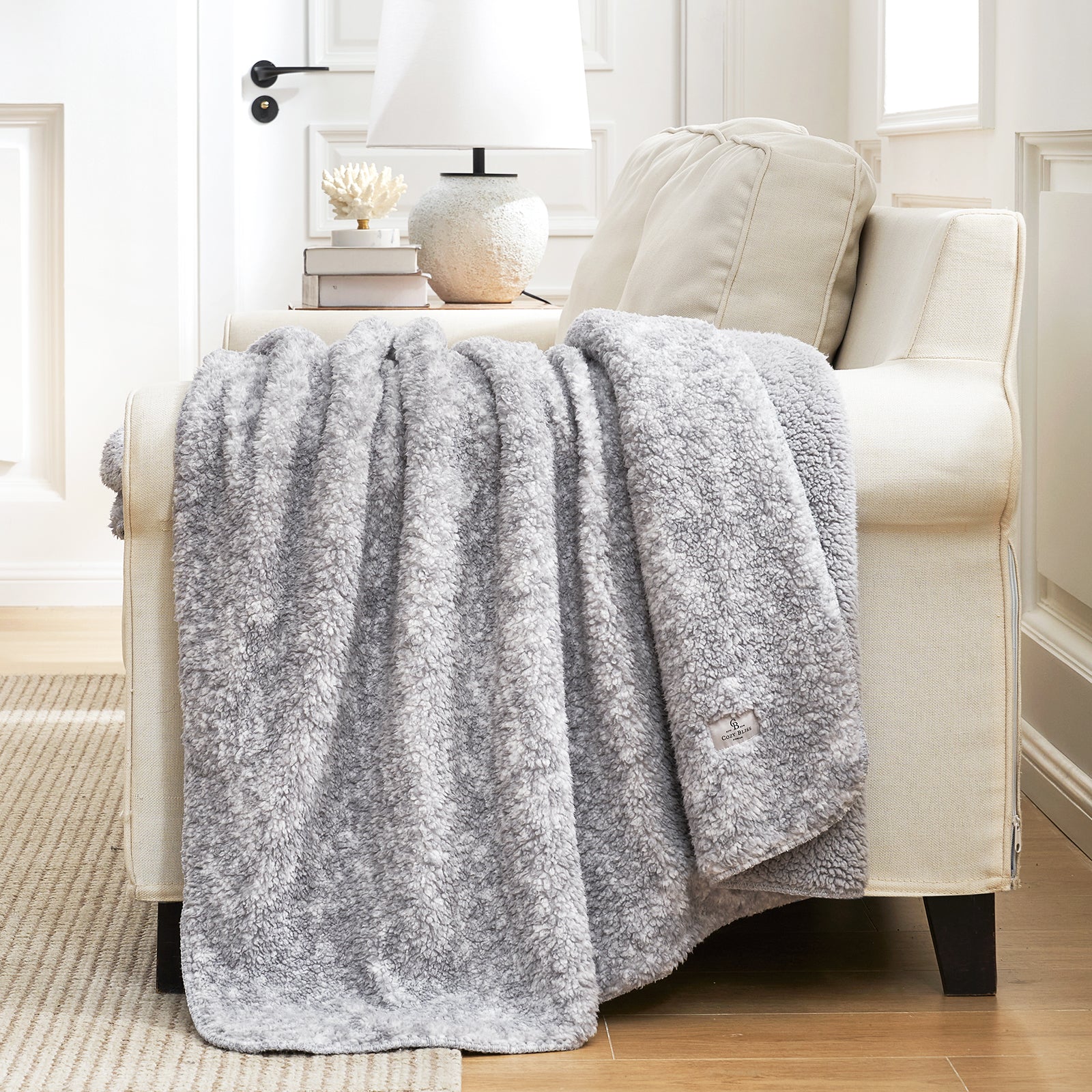 Cozy Bliss gray Sherpa blanket on sofa. Soft, warm, and breathable blanket for cozy comfort. #color_ Mottled Grey