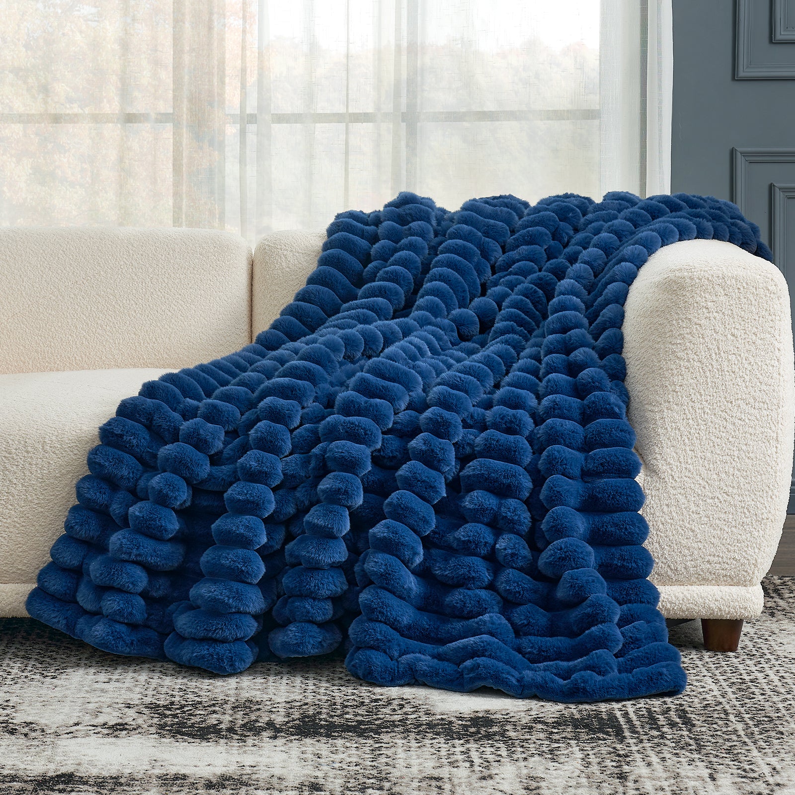 Cozy Bliss navy blue faux fur throw blanket draped on a sofa, offering cozy comfort and stylish design. #color_Navy Blue