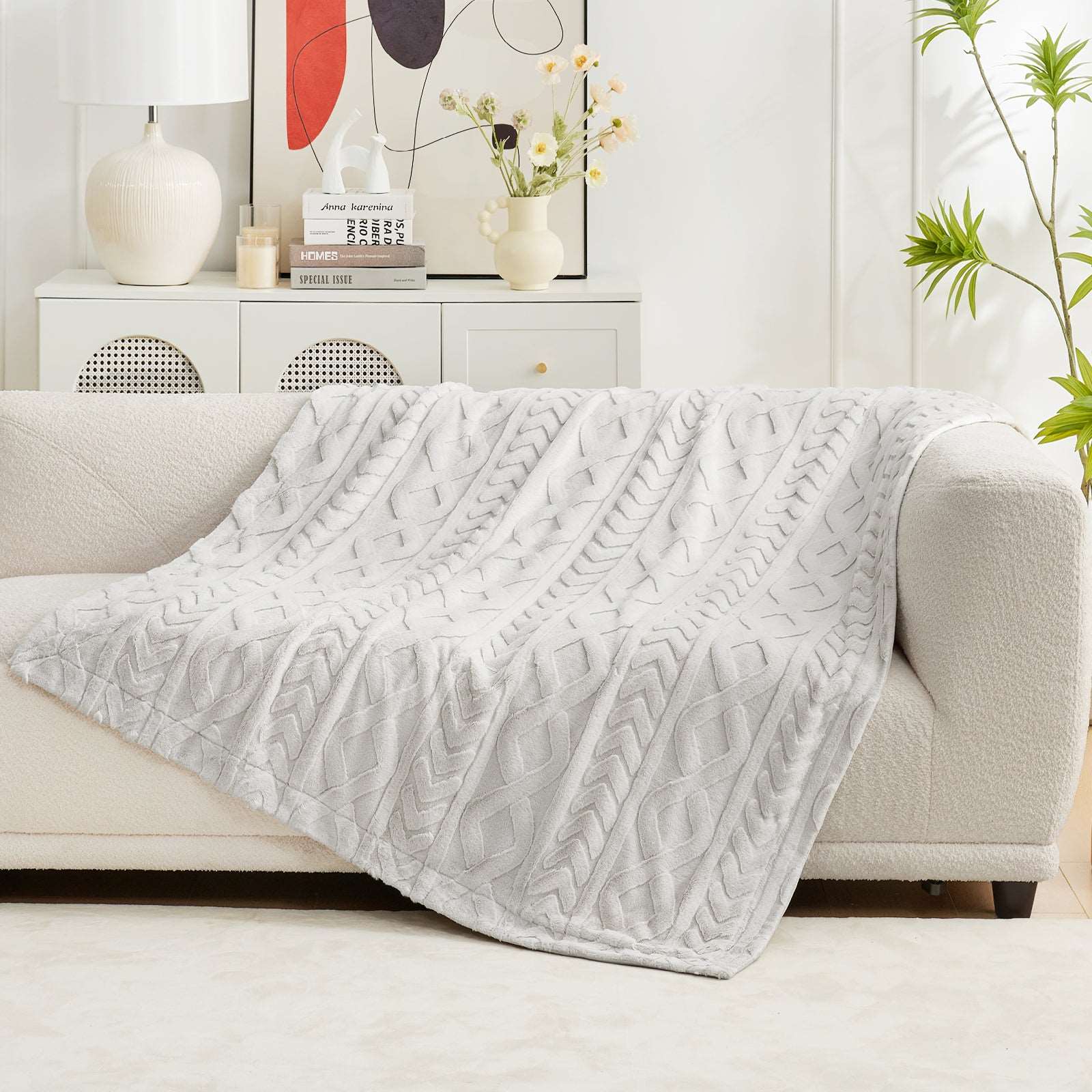 Cable knit faux fur throw blanket in light gray draped over a cream-colored sofa, cozy home decor #color_Beige