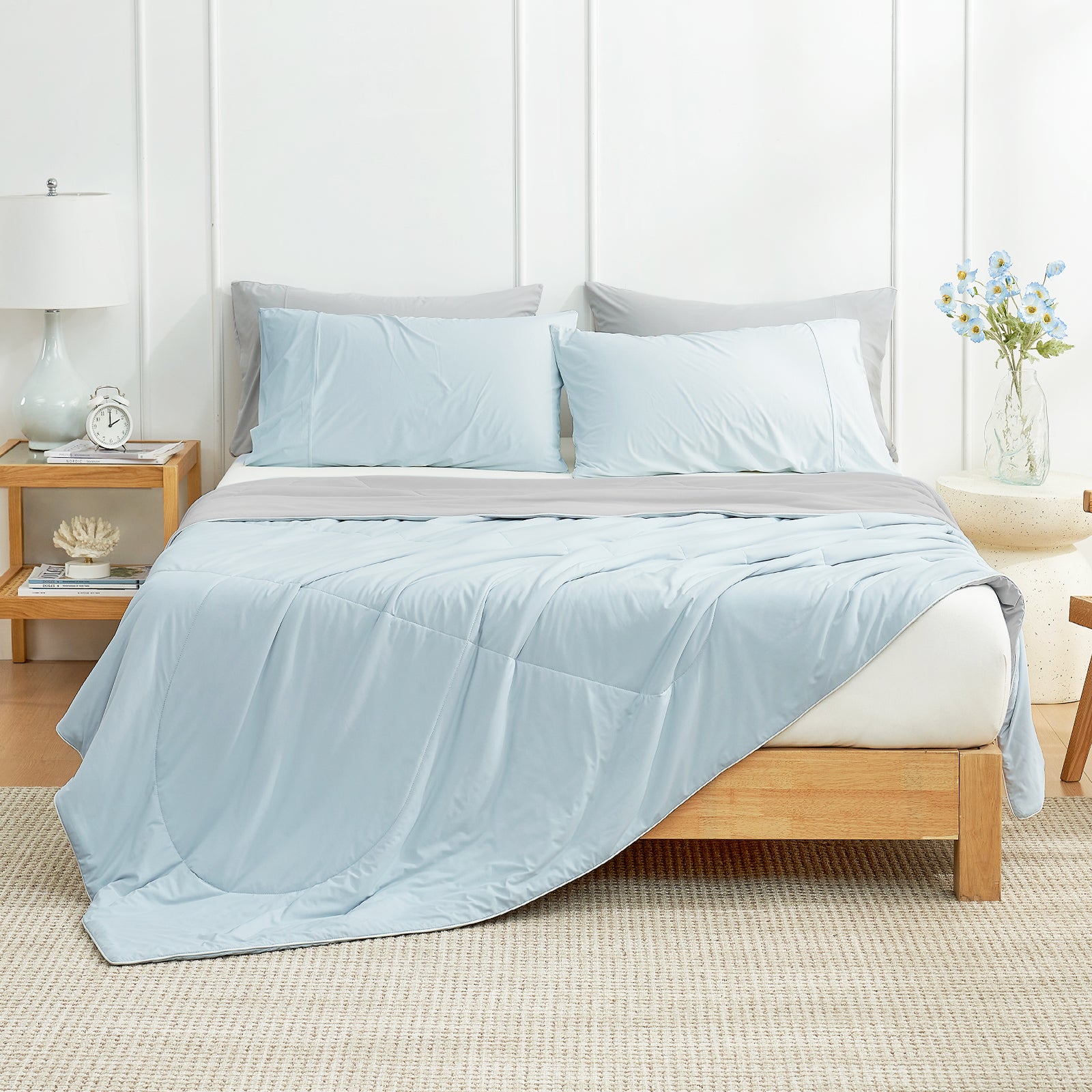 Light blue cooling comforter and pillows on a bed with gray sheets. Cozy bedding. #Color_Grey/Blue