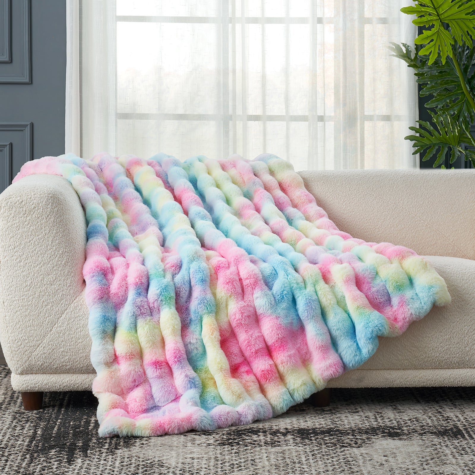 Cozy Bliss rainbow tie-dye faux fur throw blanket draped over a white sofa, soft and cozy #color_Tie-dye Rainbow