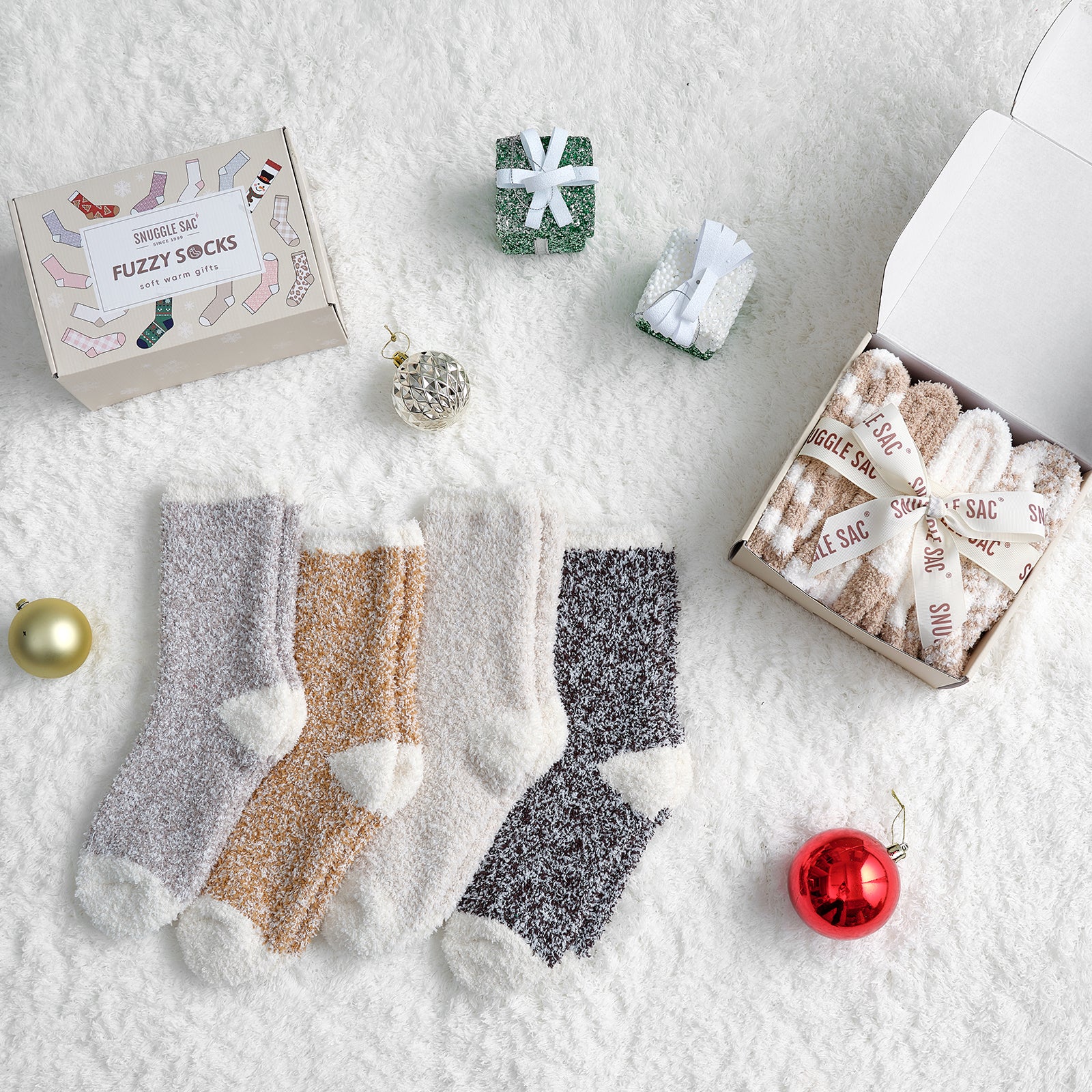Fuzzy socks with packaging and Christmas ornaments on a snowy background #color_mixed