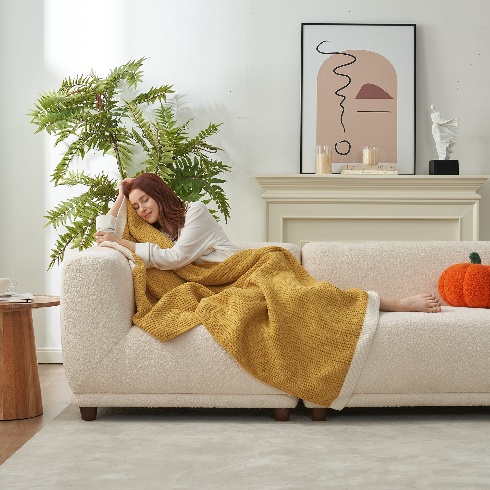 Woman resting on a sofa with a Chenille Waffle Knit Throw Blanket in Yellow. #color_Yellow