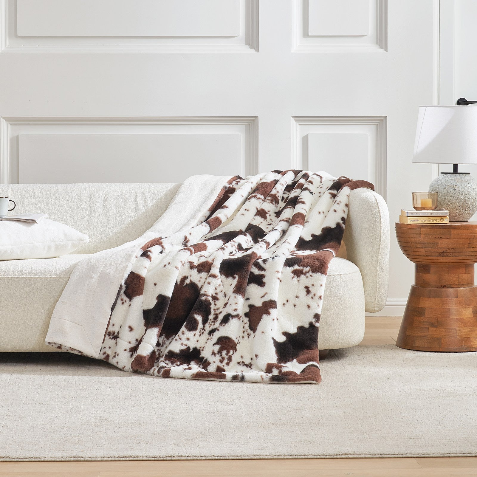 Cow print faux fur blanket draped over a sofa; cozy bedding and living room decor #color_Black/Coffee