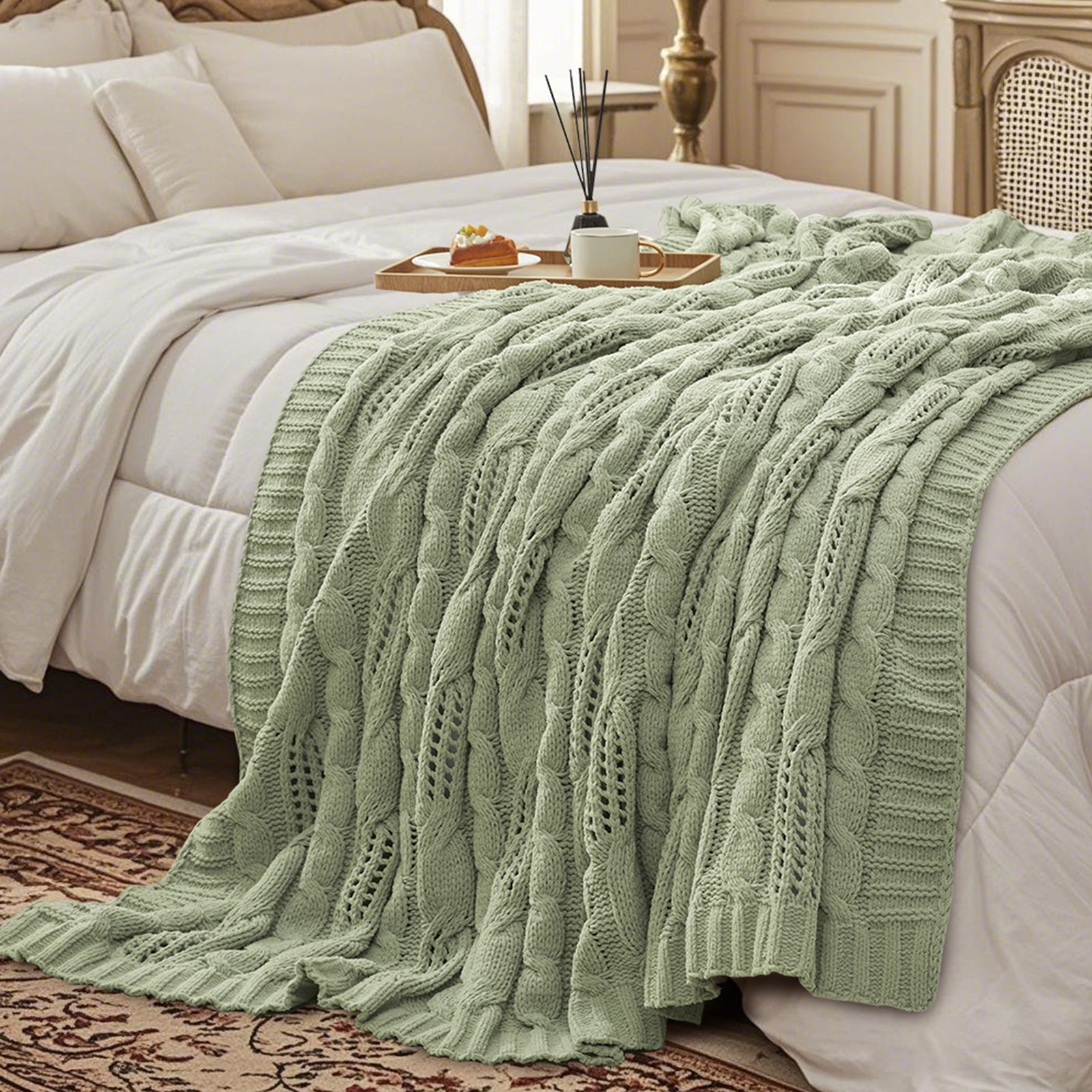 Chenille Cable Knit Throw Blanket in Sage Green styled on a bed in a cozy bedroom, adding a calm and inviting atmosphere. #color_Sage Green