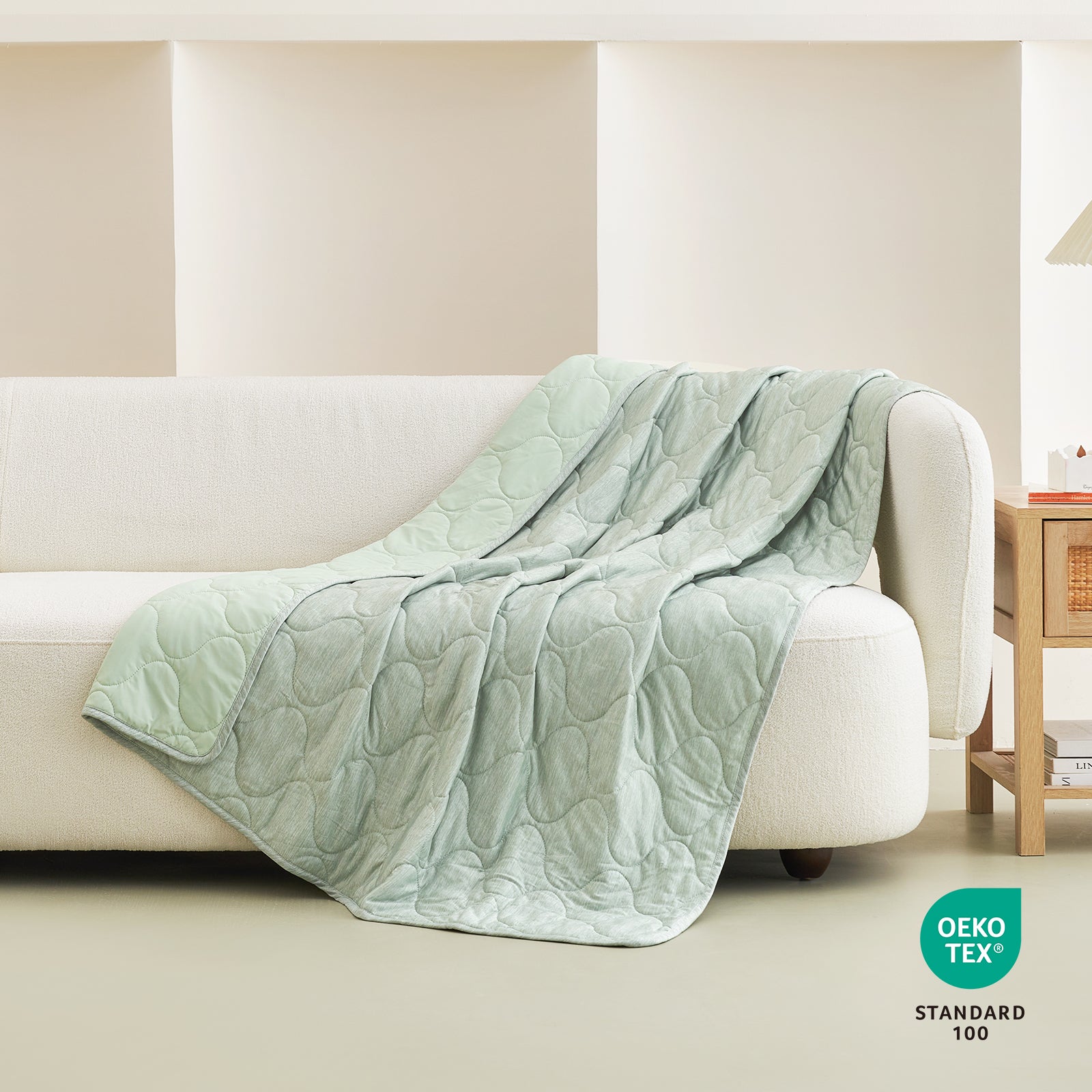 Cozy Bliss cooling blanket draped over a sofa #color_Sage Green