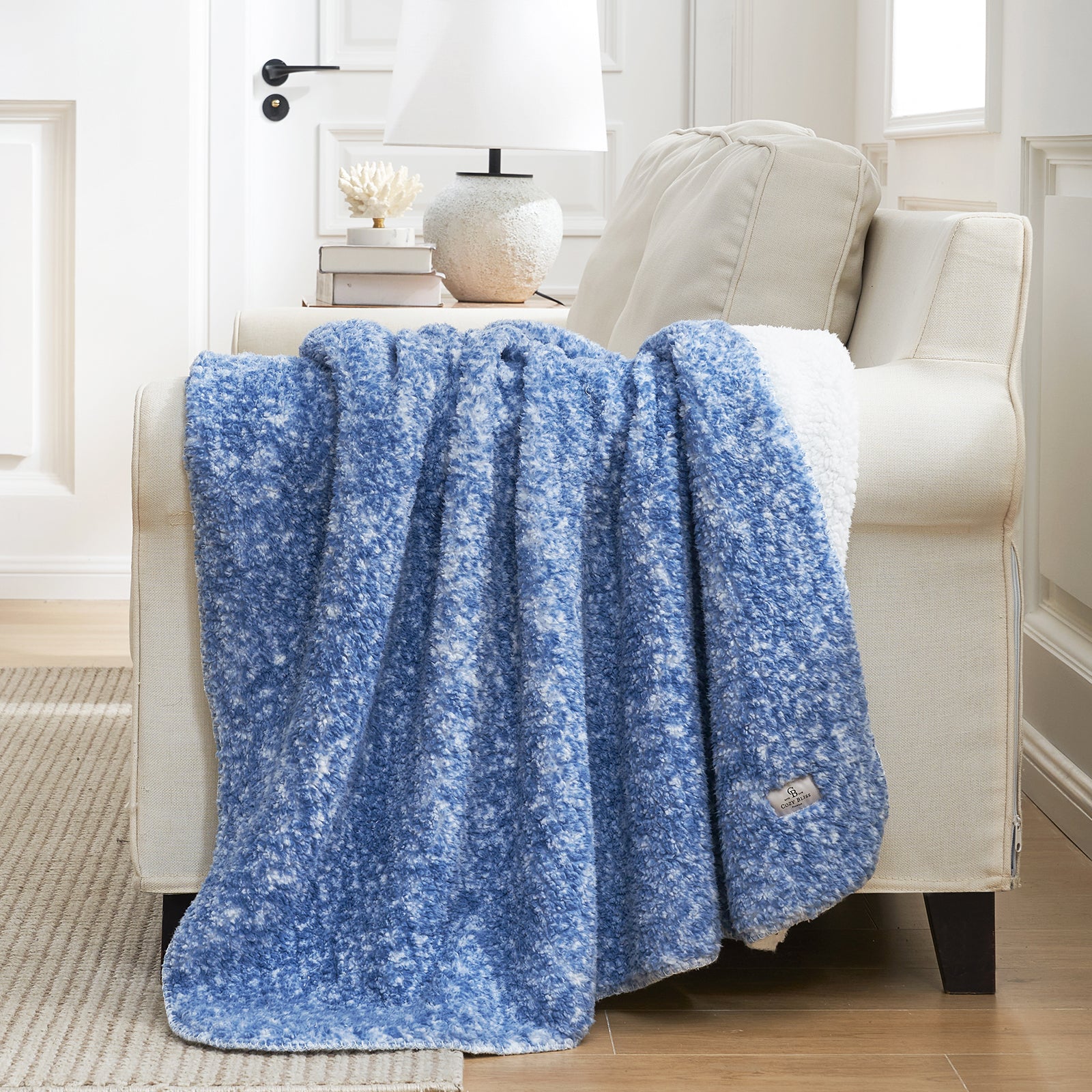 Cozy Bliss reversible blue and white Sherpa throw blanket on sofa, soft and breathable. #color_ Mottled Navy Blue