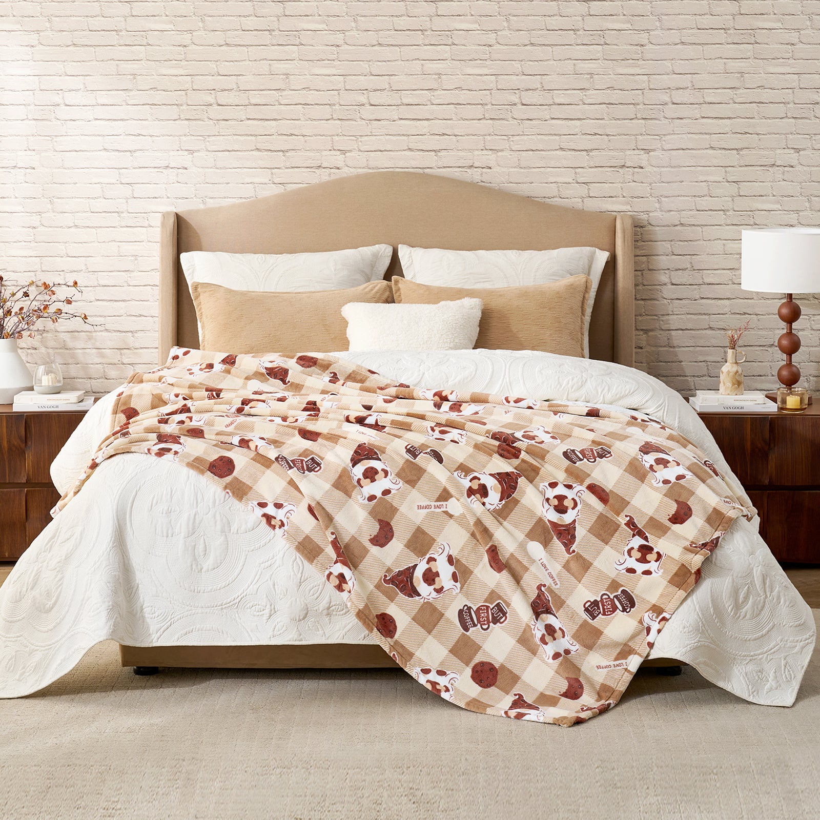 Bed with plaid blanket and pillows against a brick wall. #color_Coffee Gnome Brown