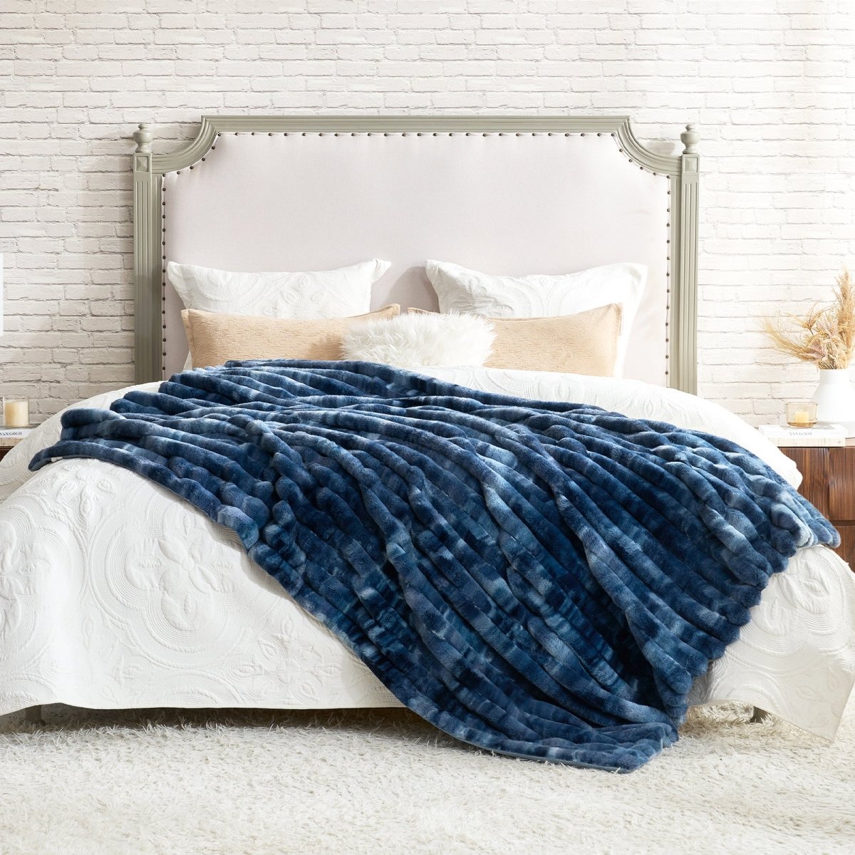 Blue blanket draped over a bed in a bedroom setting. #color_Tie-dye Blue