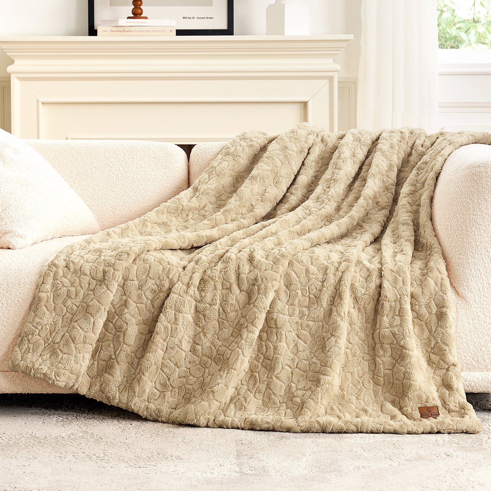 Beige textured blanket draped over a white sofa in a cozy living room. #color_Khaki