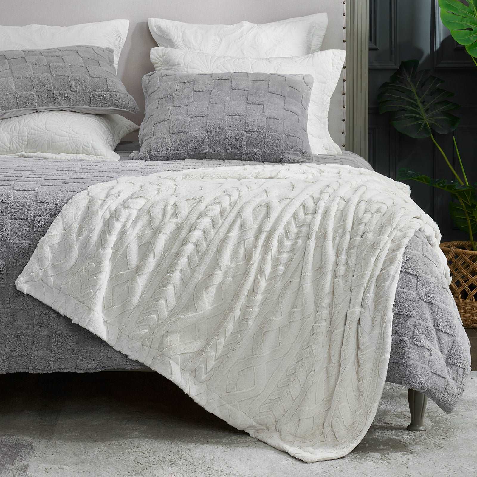 Cozy cable knit faux fur throw blanket in white on bed with gray pillows, cozy bedding #color_Beige