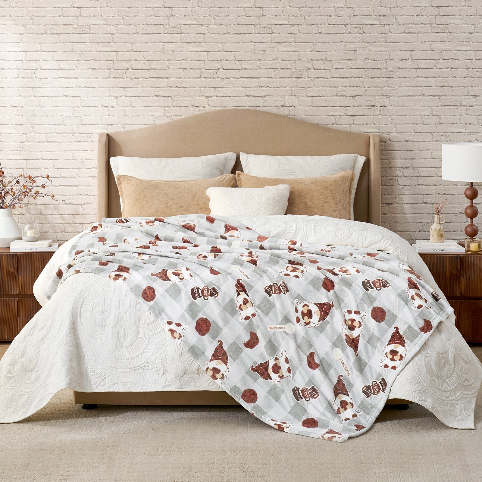 Bed with patterned comforter and pillows against a brick wall. #color_Coffee Gnome Grey