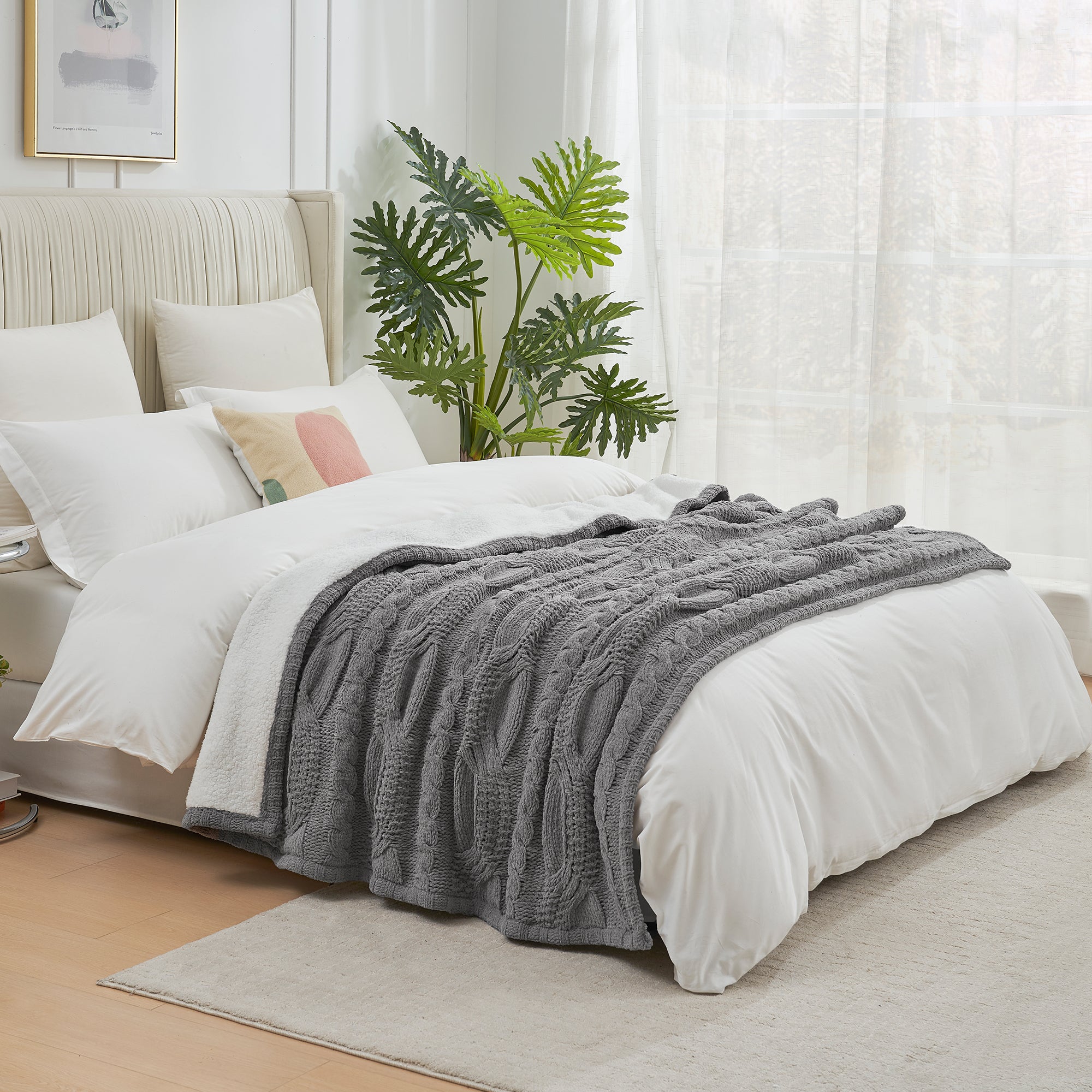 Bedroom with a bed featuring white bedding and a gray blanket, a plant, and light curtains. #Color_Grey