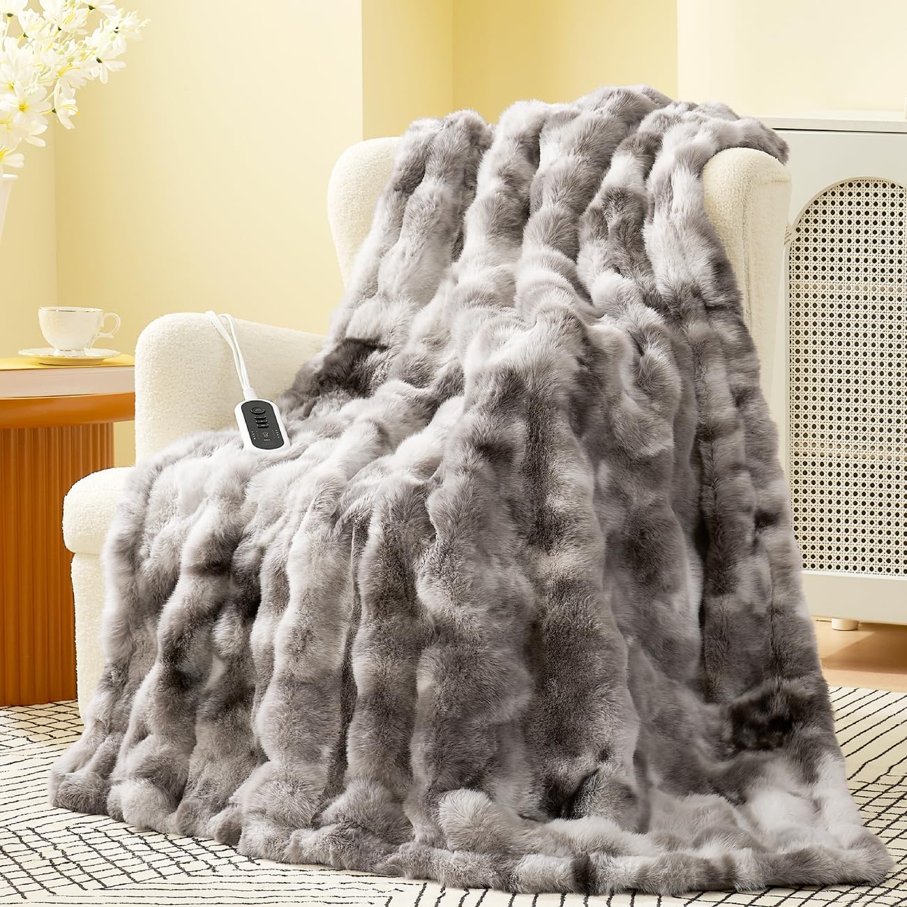 Gray faux fur blanket draped over a chair in a cozy room. #color_Tie-dye Taupe